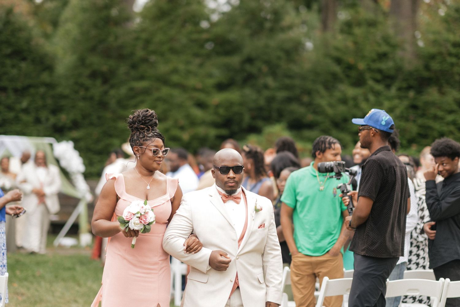 Wedding celebration with guests in formal attire gathered outdoors.
