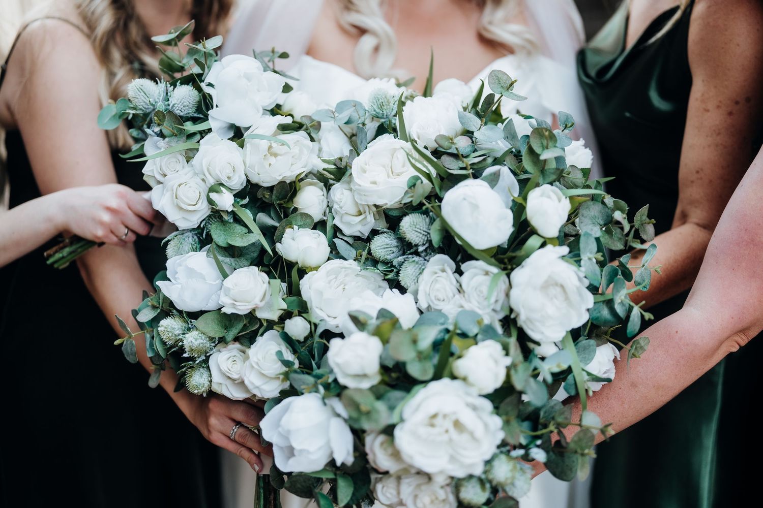 Close-up of luxurious white rose and eucalyptus wedding bouquet.