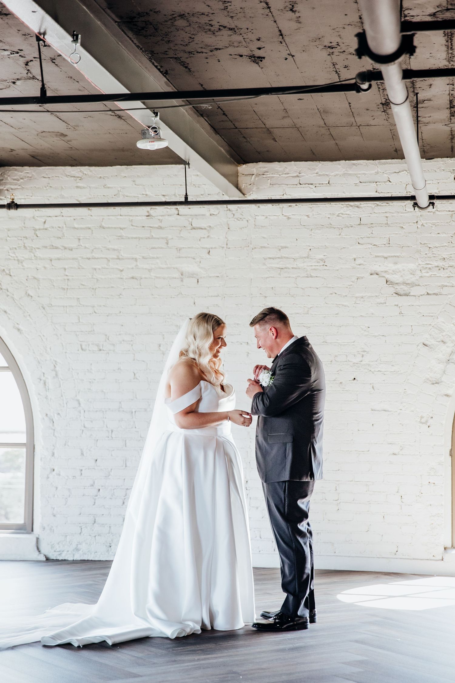Wedding first look sequence showing emotional reactions in white brick venue.