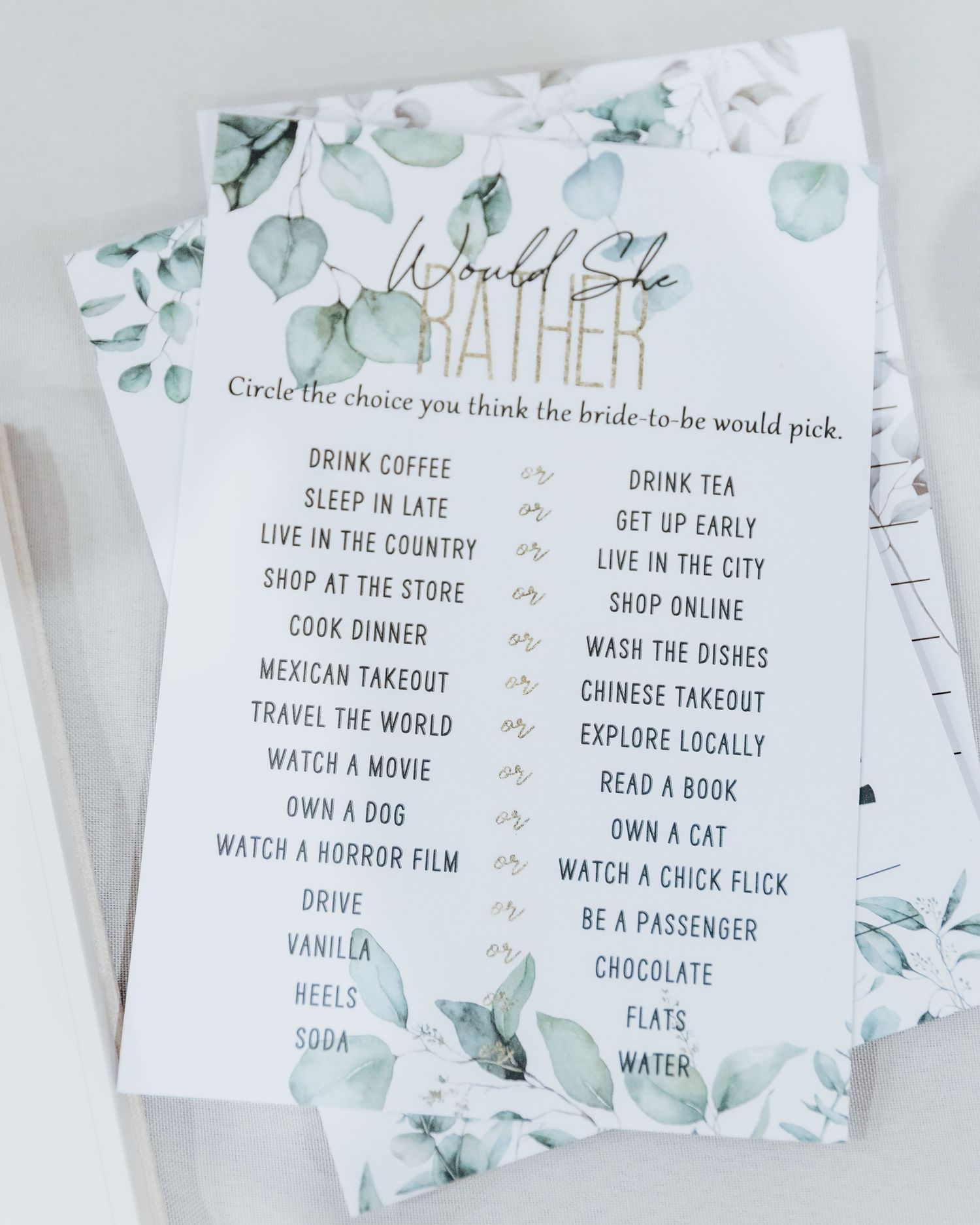 Wedding game card with eucalyptus design listing fun bride preference choices.