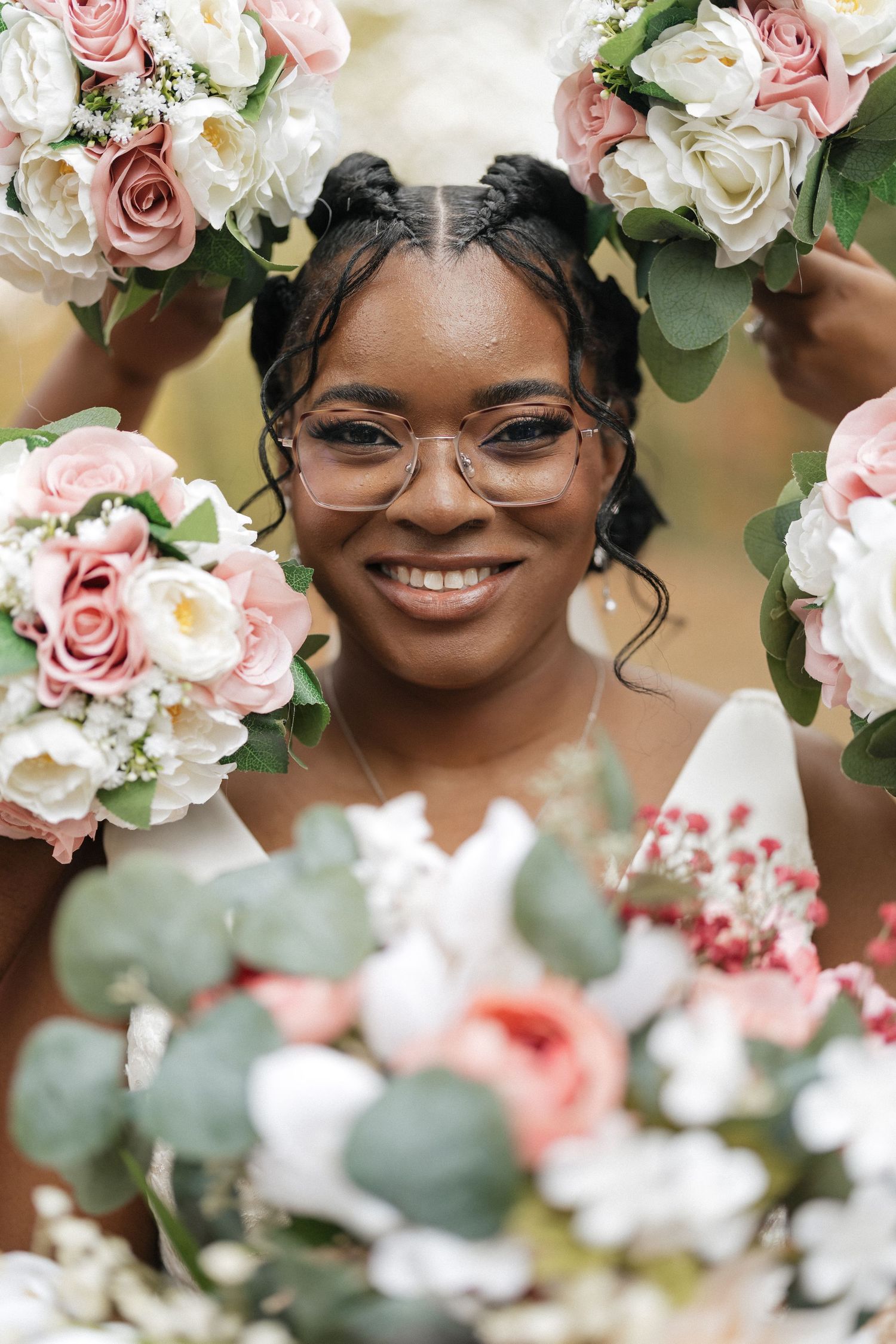Delicate pink and white roses frame a romantic wedding portrait through floral arrangements.