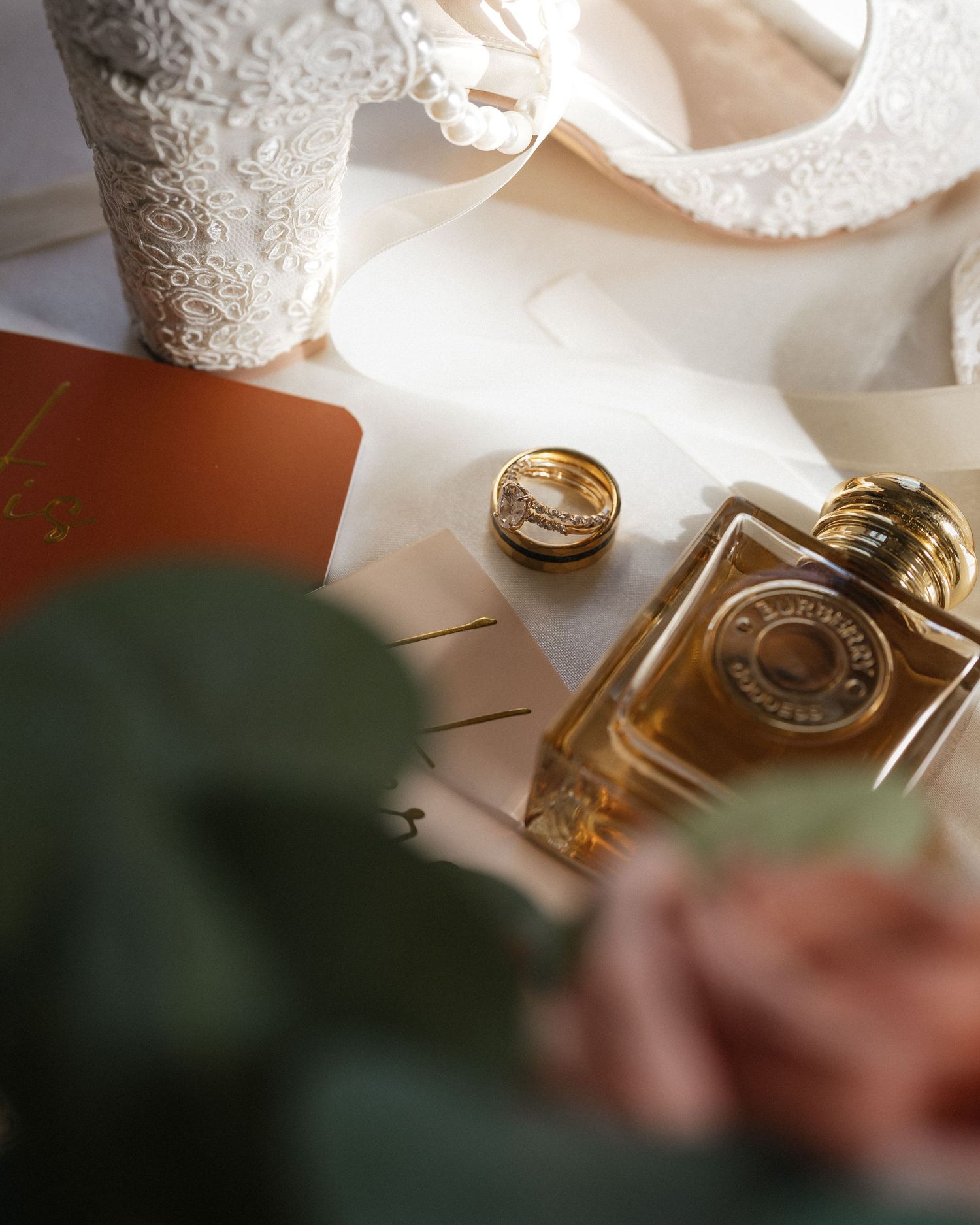 Close-up shot of gold wedding rings and jewelry on a white surface with soft lighting.