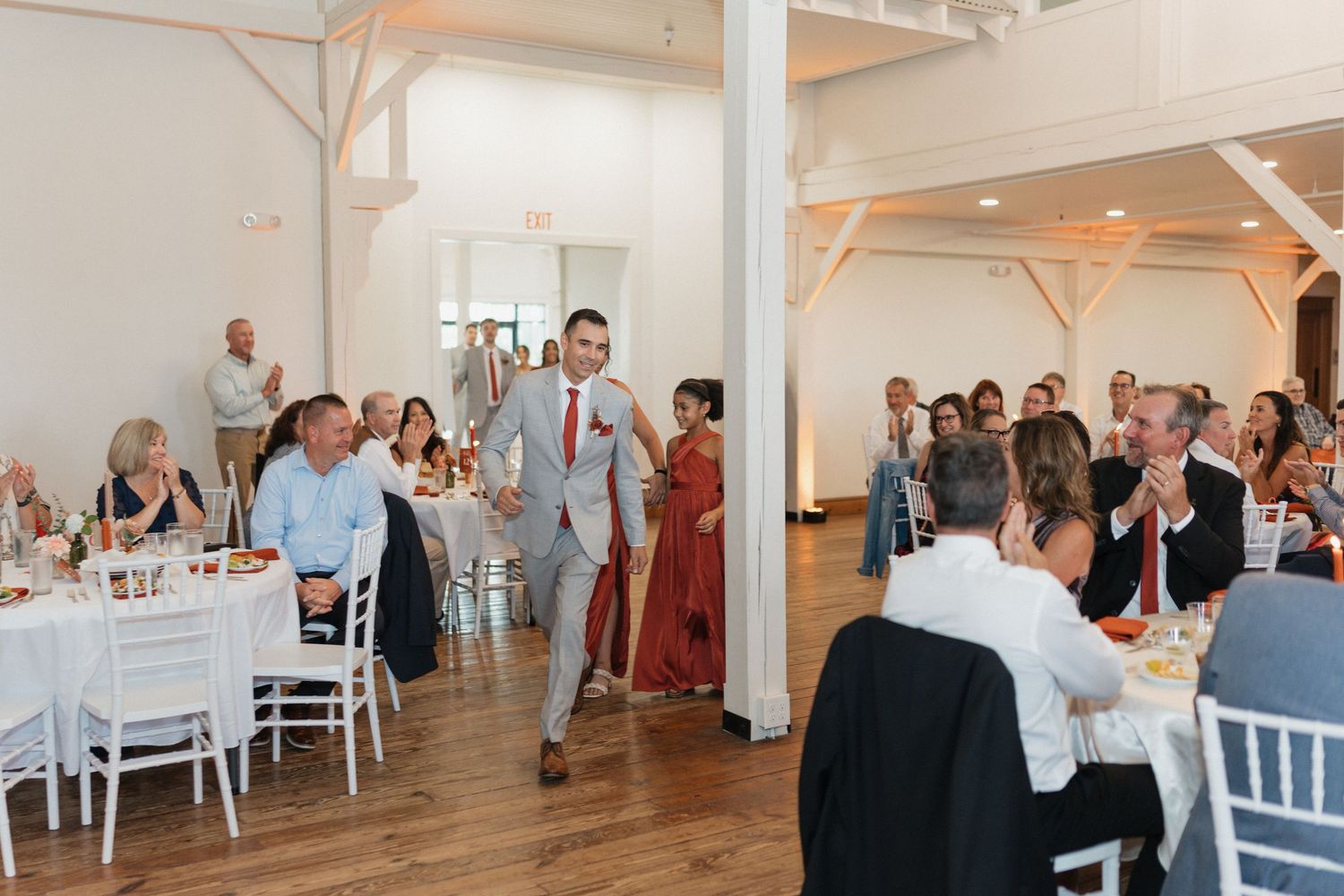 White modern wedding reception venue with elegant table settings and decor.