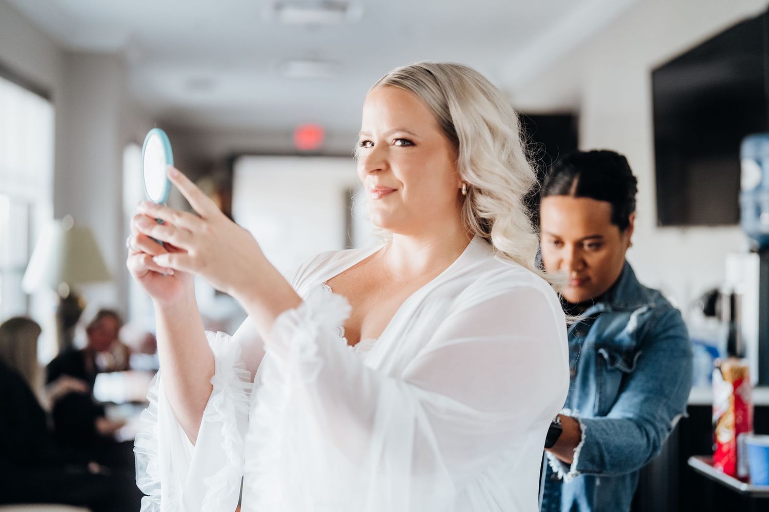 Wedding preparation scene showing people in white robes getting ready in a bright modern room.