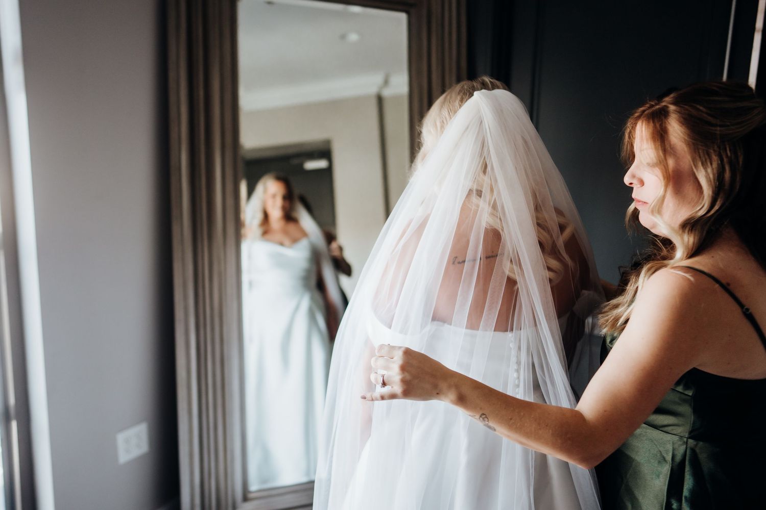 Wedding preparations showing dress and veil being arranged in a hotel room.