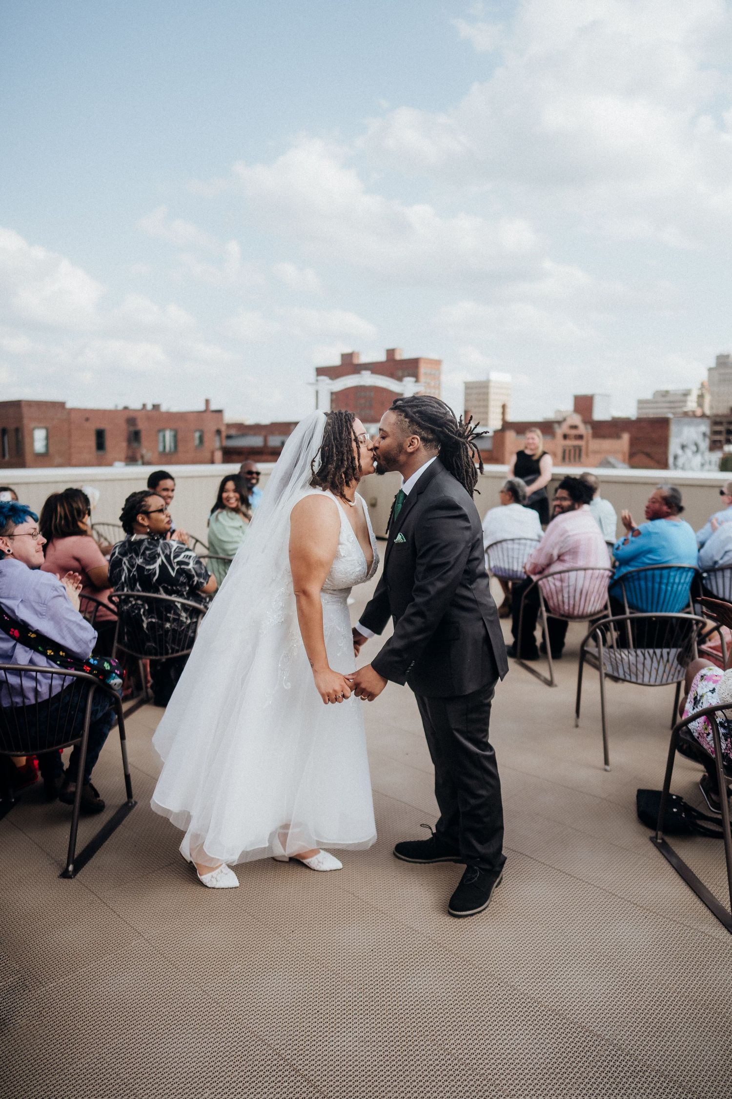 A couple shares their first dance at an outdoor rooftop wedding ceremony.
