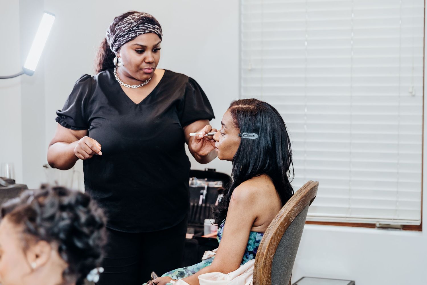 Professional makeup artist applies cosmetics to a client in a salon setting.