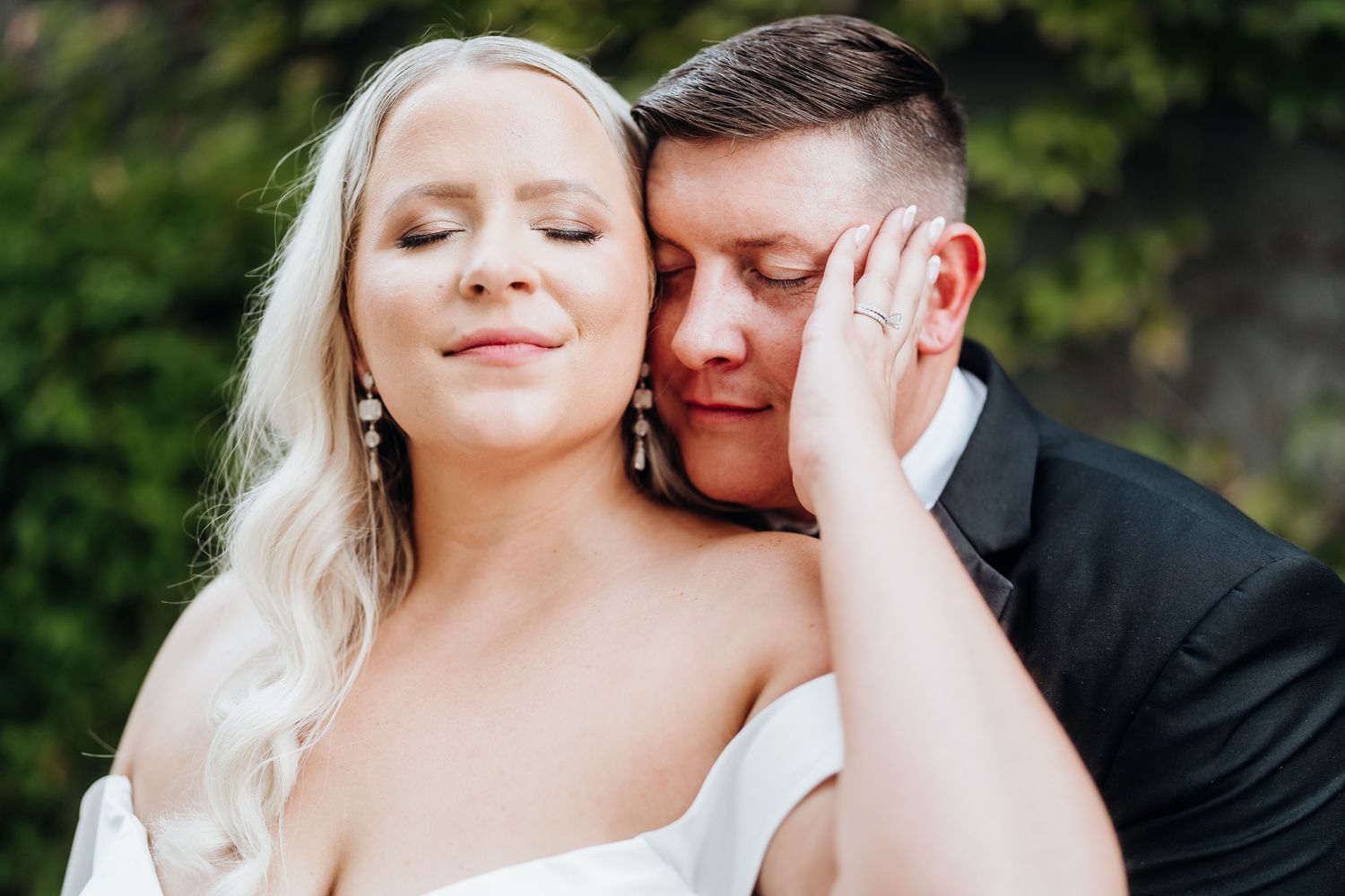 Intimate wedding portrait captured outdoors with soft natural lighting.