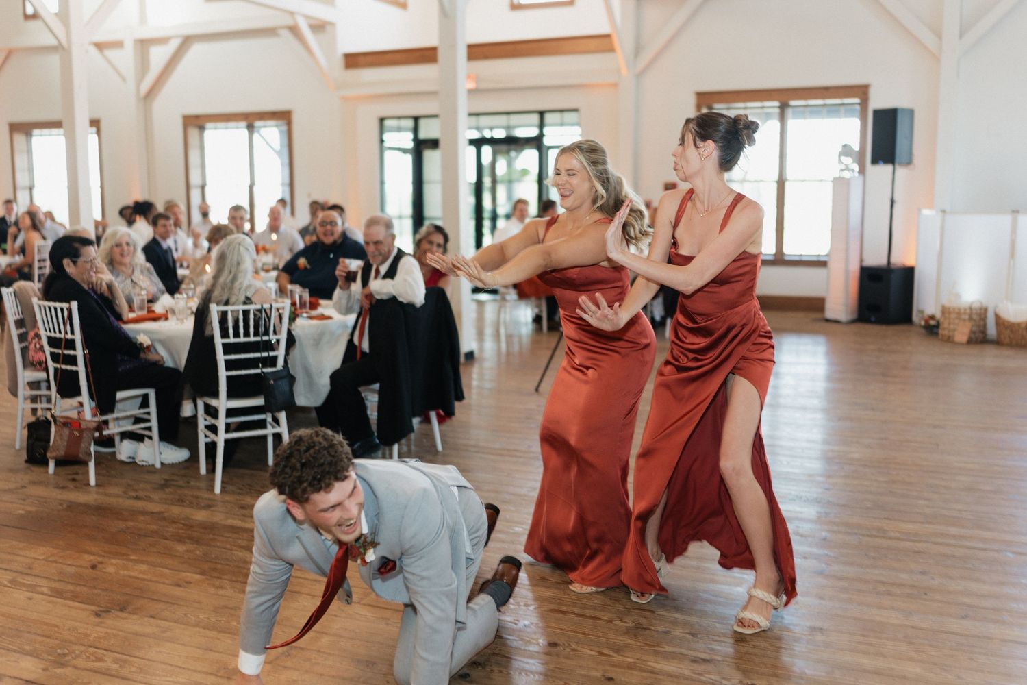 Wedding reception celebration with guests dancing and enjoying themselves in an elegant white venue.