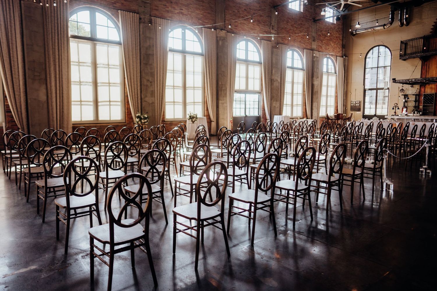 Panoramic view of an empty wedding reception venue with rows of chairs.