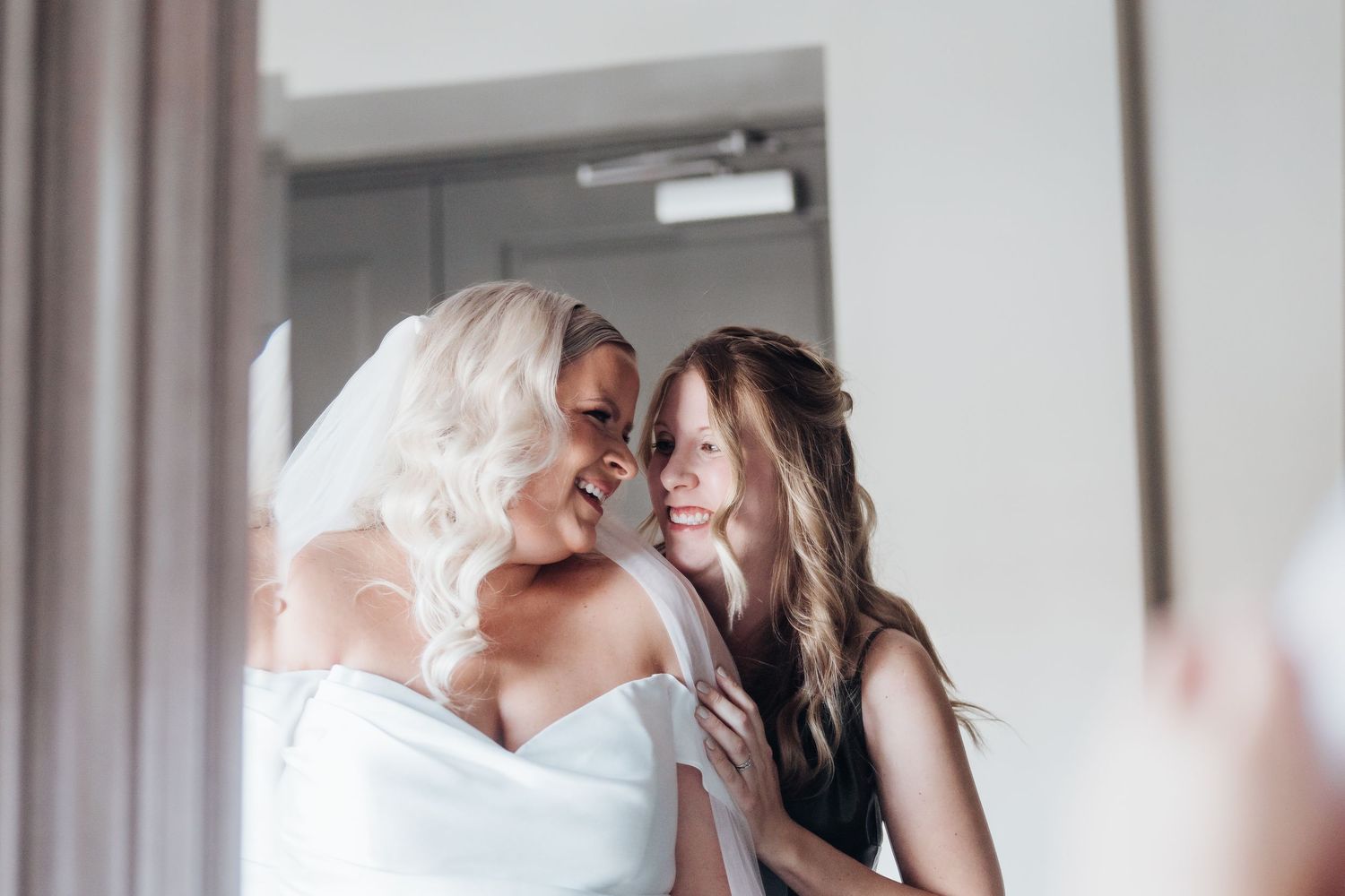 Intimate moment captured in soft focus with flowing white fabric and delicate details.