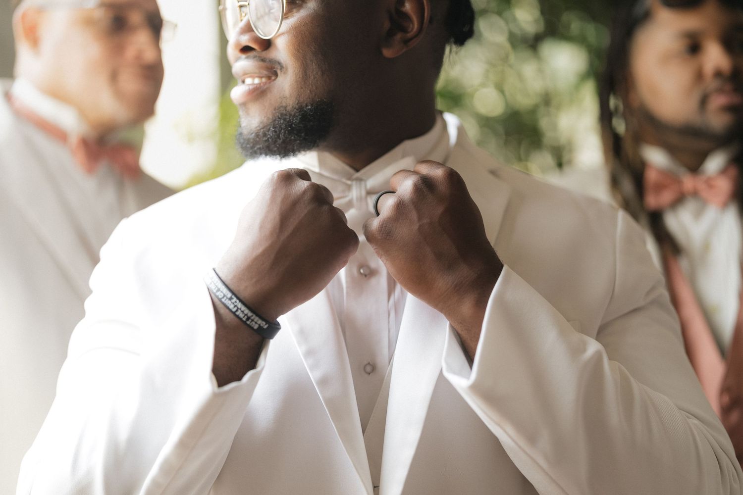 Groomsmen in white dress shirts share laughter and smiles during a wedding celebration.