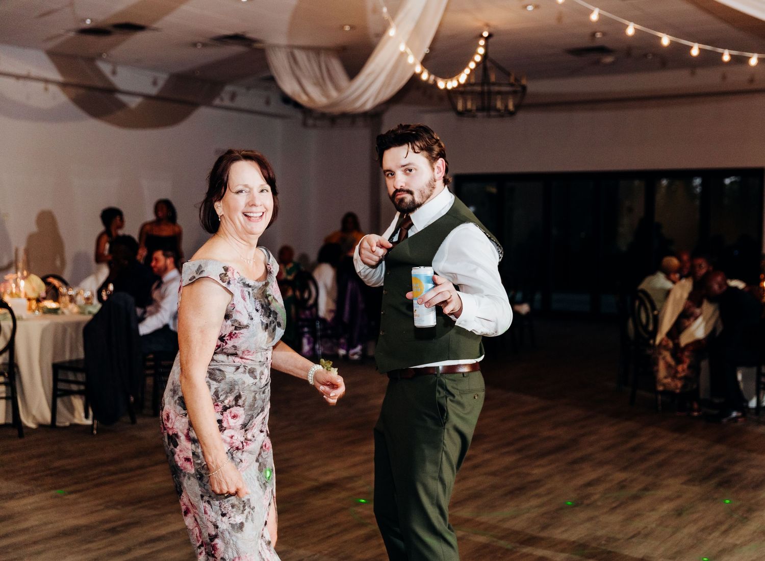 Couple dancing together on wooden floor during wedding reception.