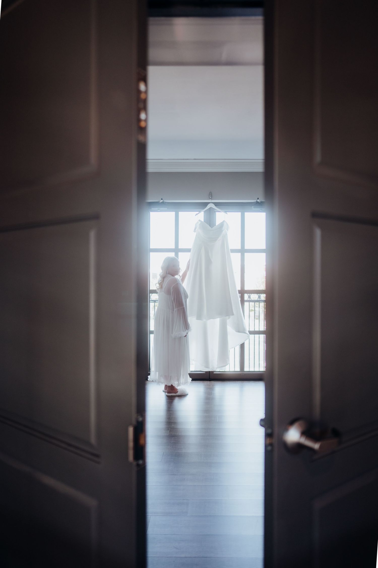 Silhouetted figures seen through doorway in bright sunlit room.