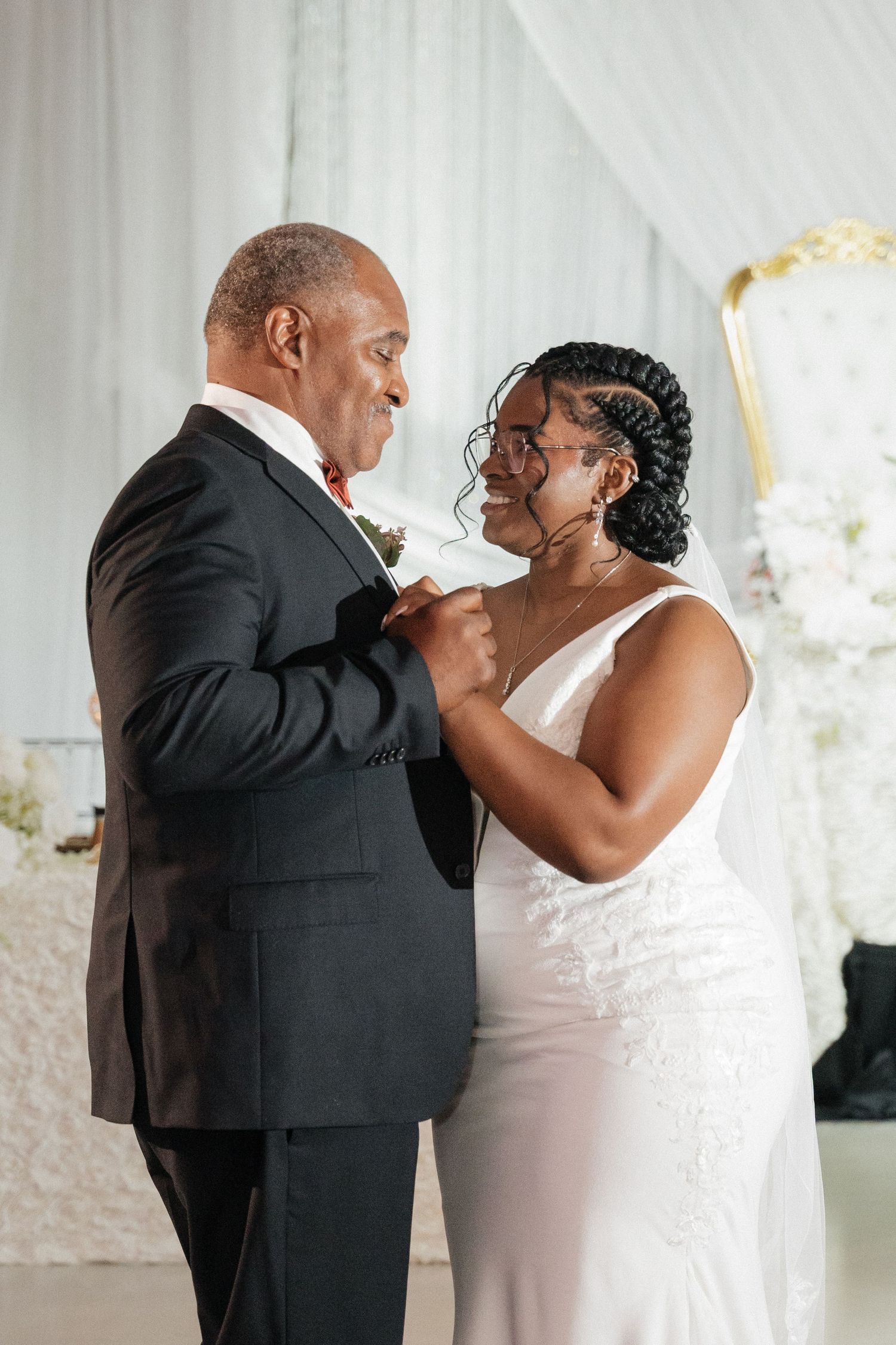 A tender moment shared during a wedding cake-cutting ceremony in a beautifully decorated venue.