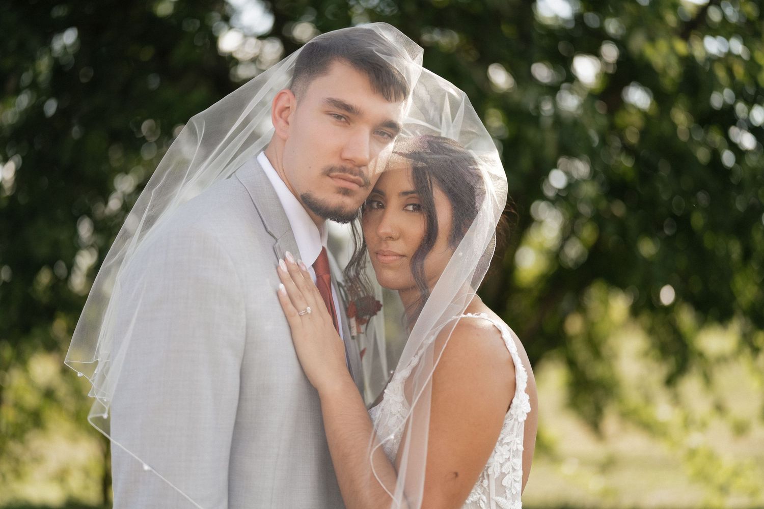 Romantic outdoor wedding portrait with soft natural lighting and flowing veil.