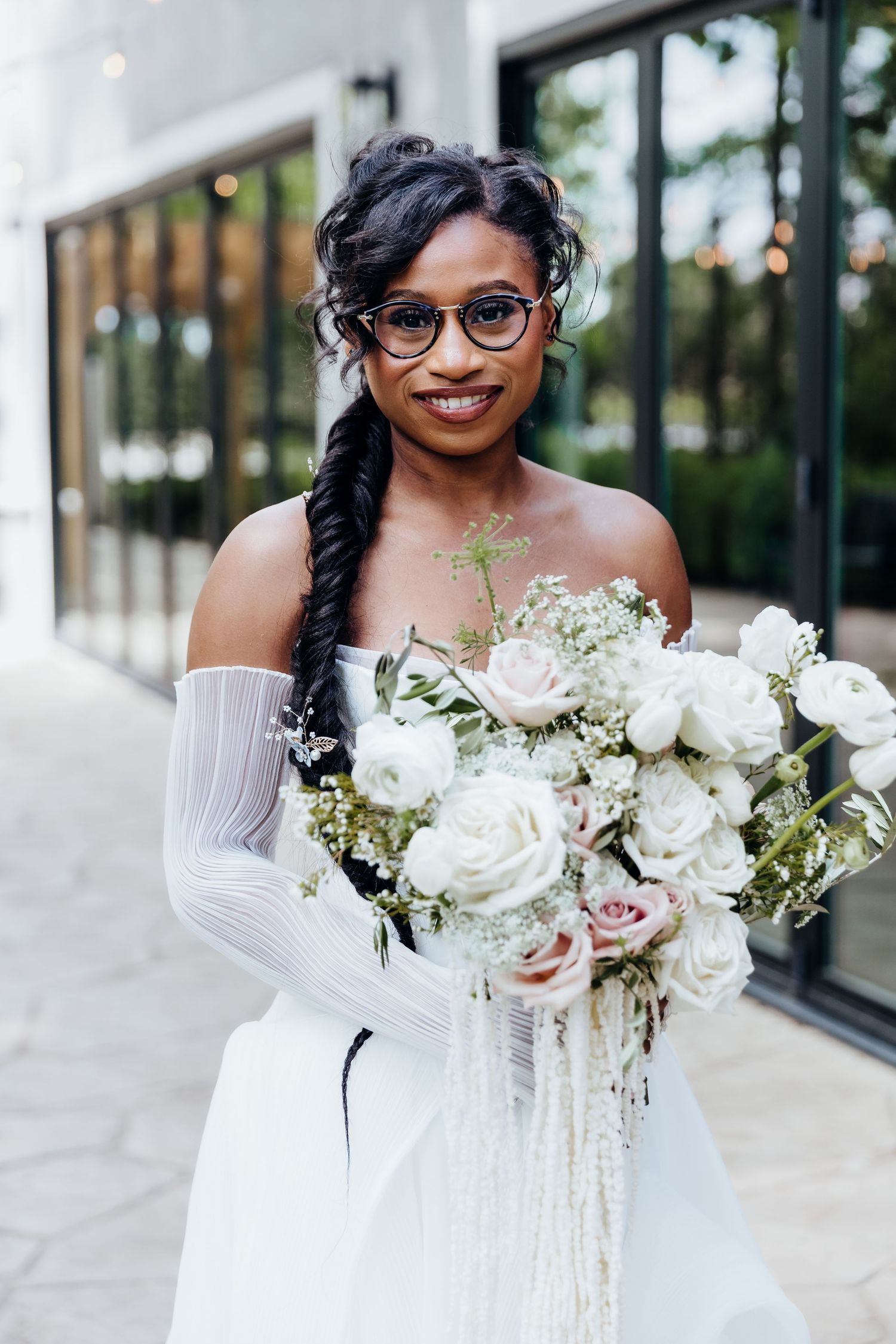Elegant bridal portrait featuring white off-shoulder gown and delicate white rose bouquet.