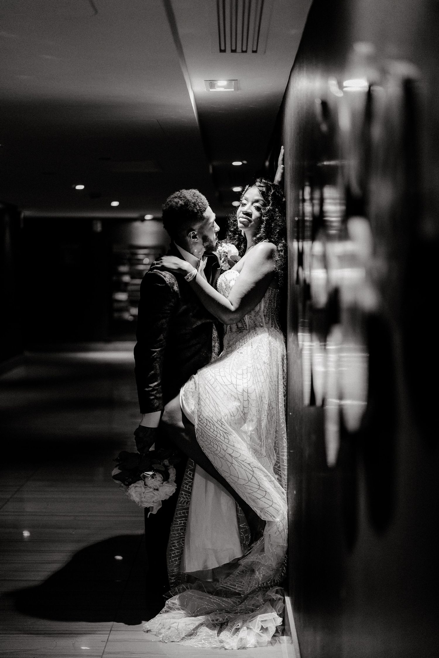 Romantic black and white wedding photo series showing couple in dramatic dance dip poses in an elegant venue.