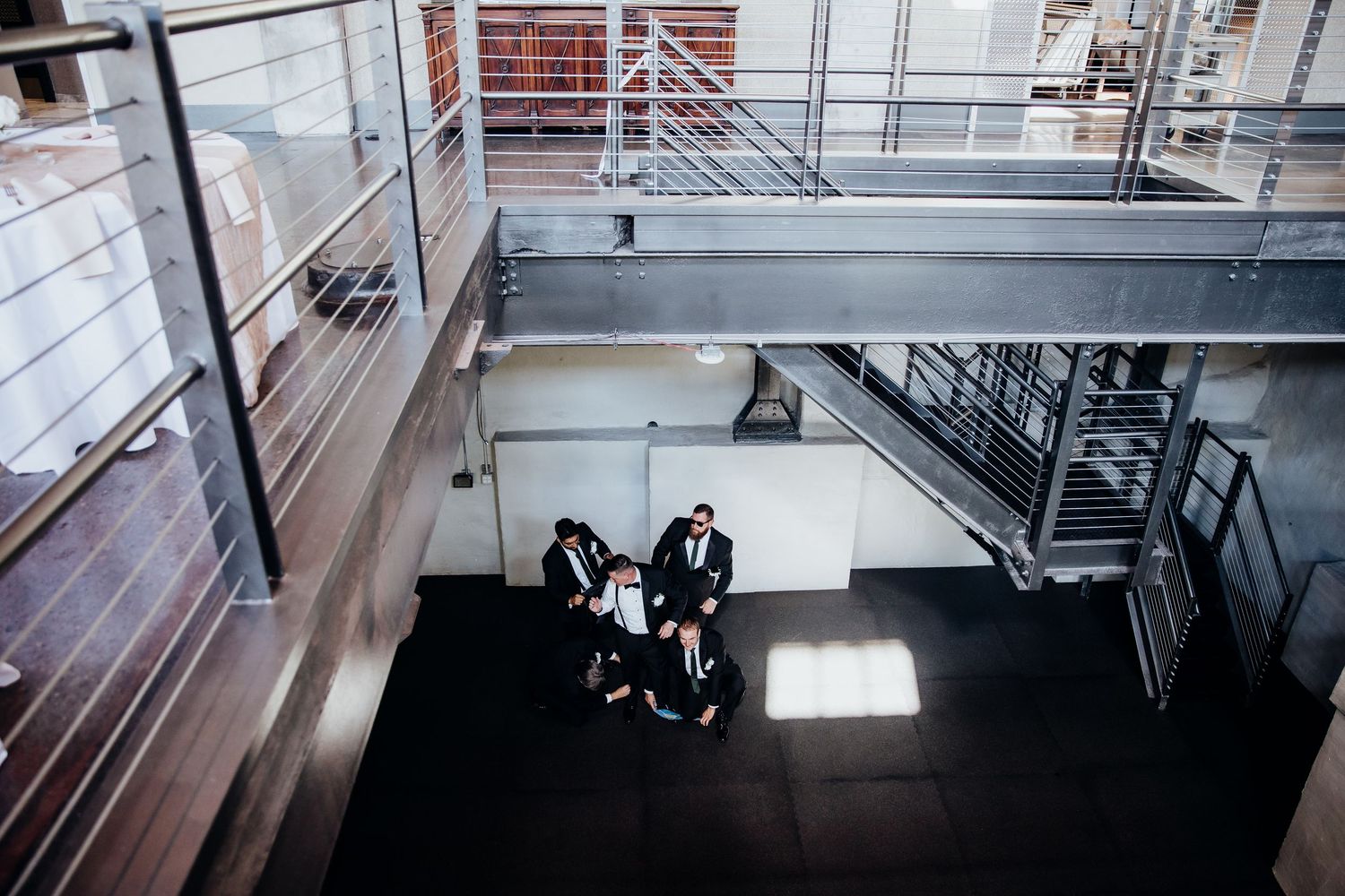 An aerial view of people gathered in an industrial-style venue with exposed beams and natural light.