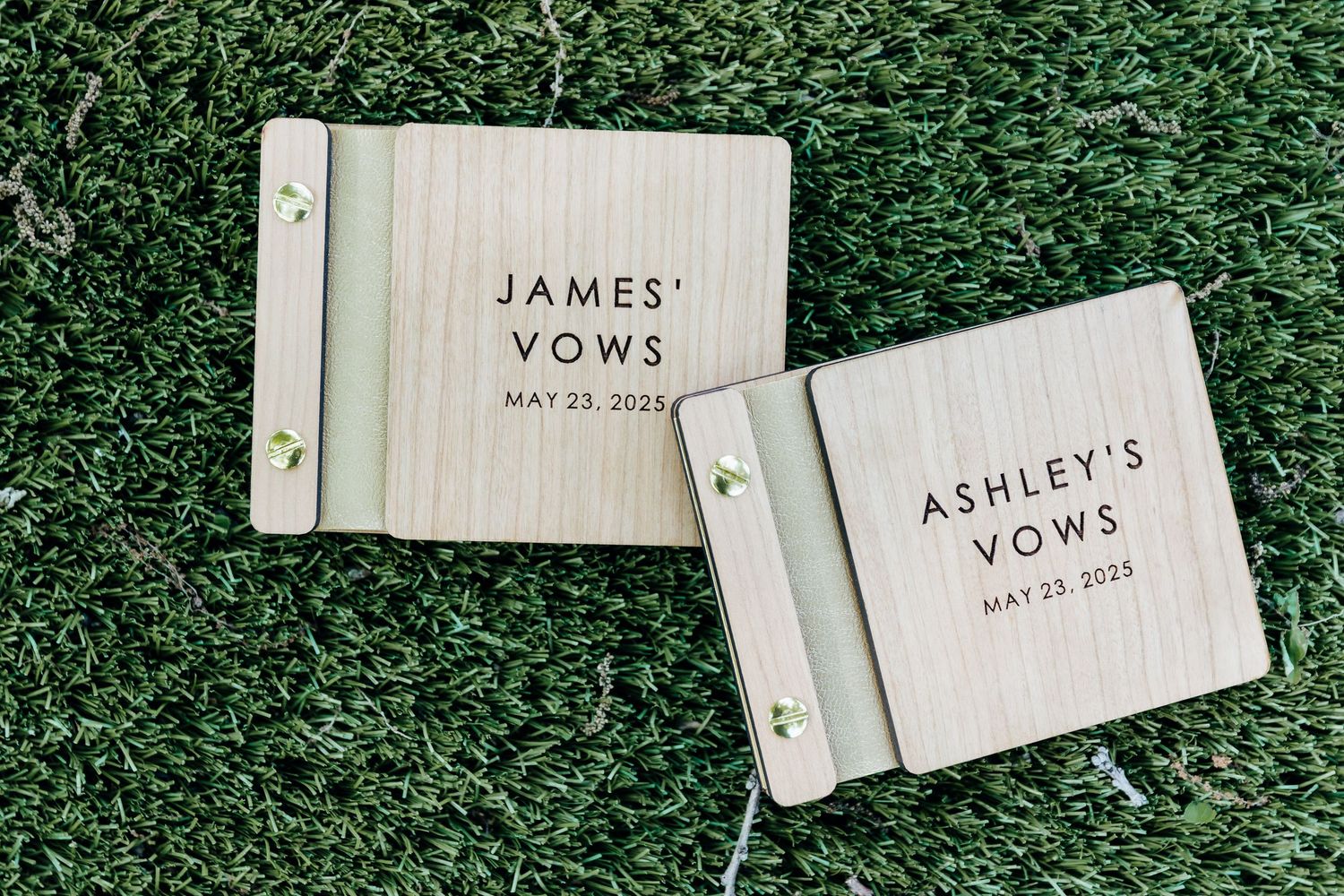 Wedding vow cards laid out on artificial grass background.