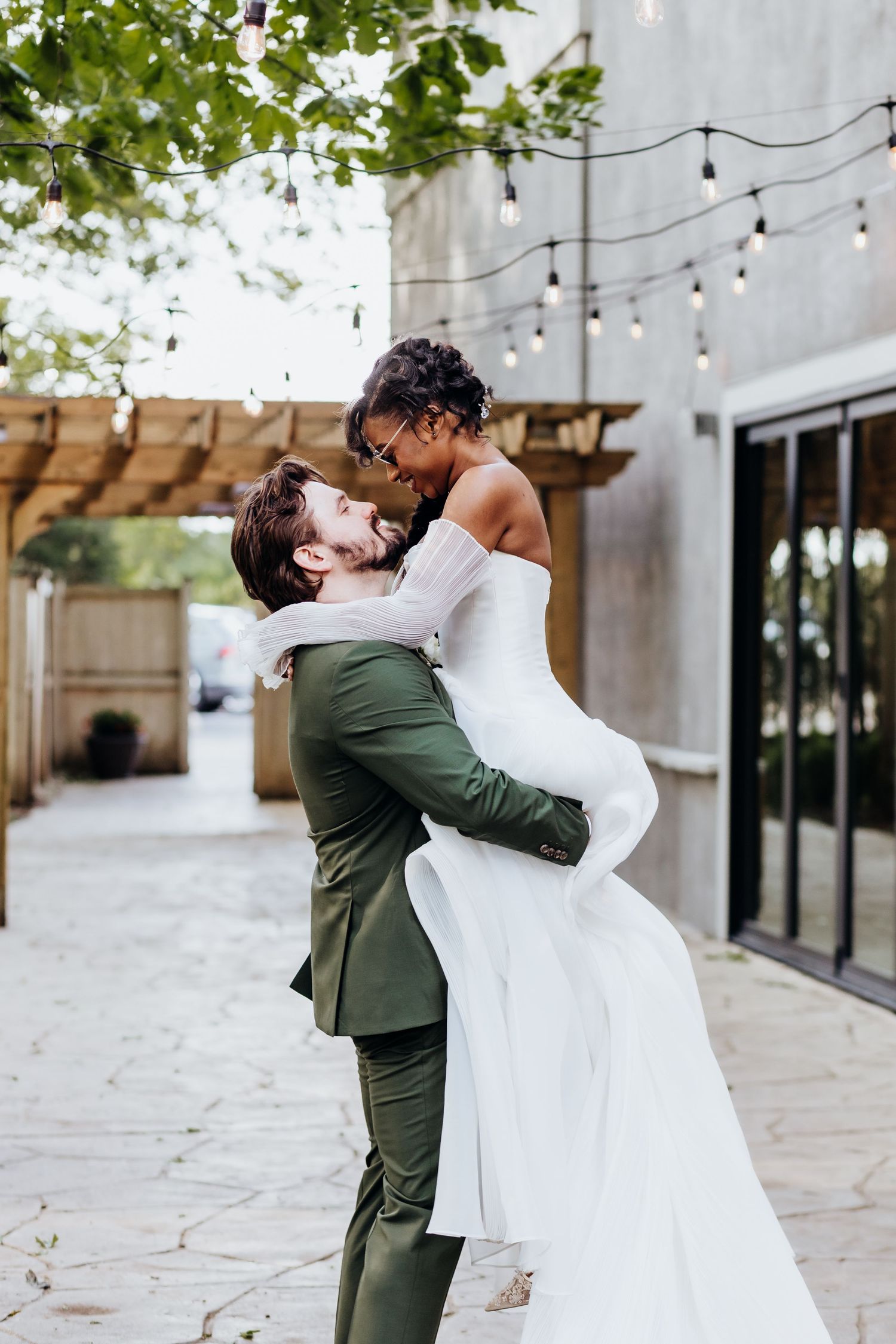 A romantic outdoor wedding photoshoot sequence showing a couple dancing and embracing under string lights and trees.