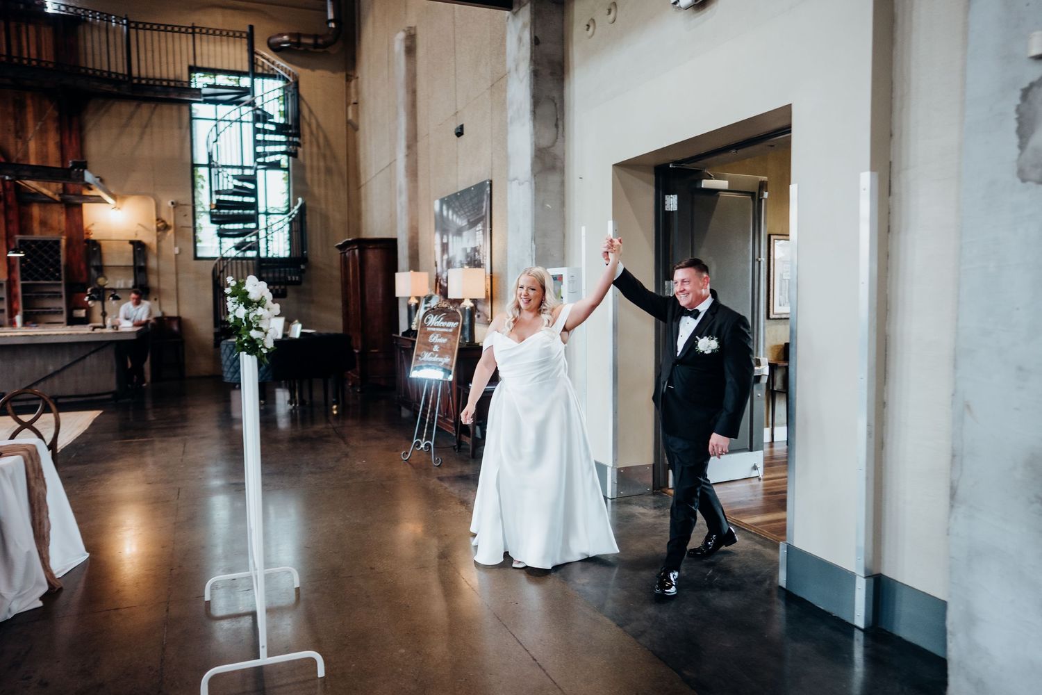 Wedding celebration in a modern industrial venue with high ceilings and minimalist decor.