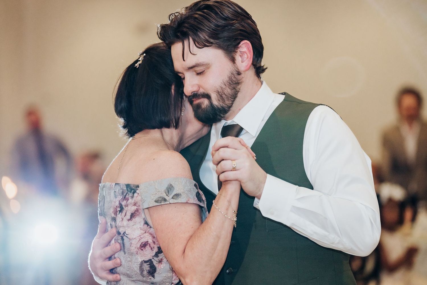 Intimate dance moment at wedding reception with soft lighting and formal attire.