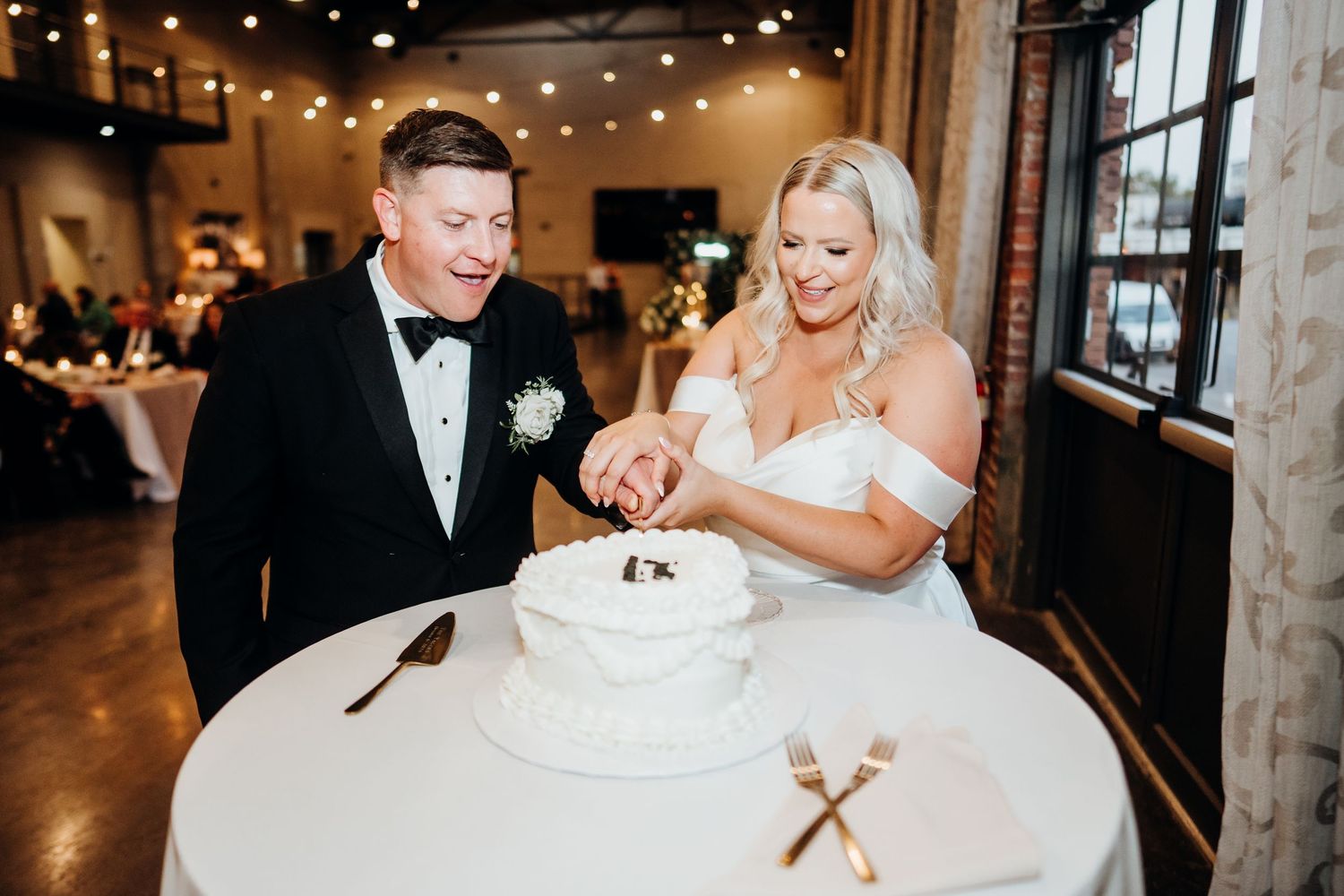Wedding reception celebration with string lights illuminating a joyful dance floor moment.