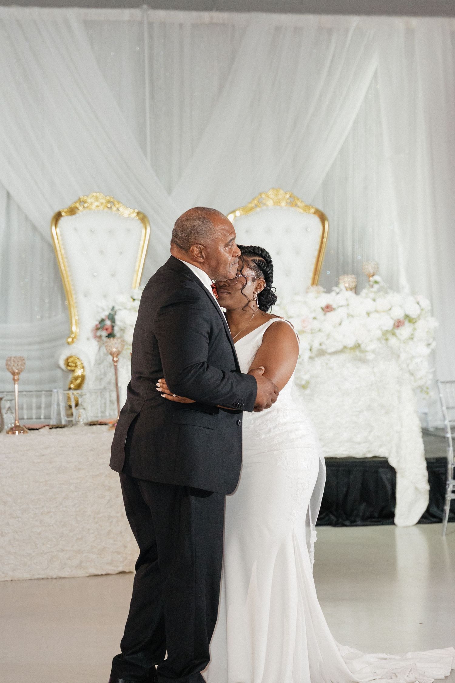 Romantic first dance moment captured in elegant white draped reception venue.