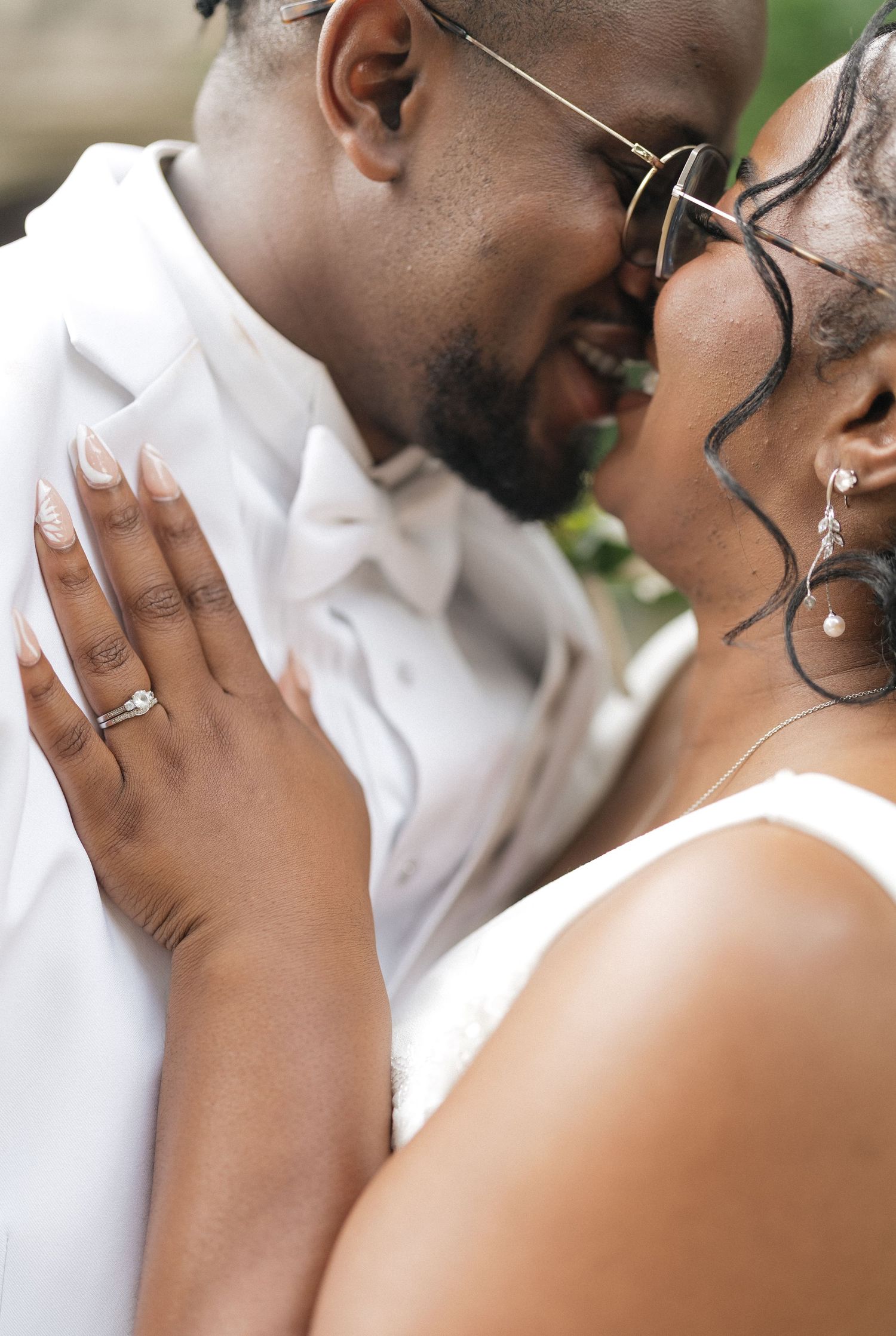 Close-up wedding photos showing tender moments and sparkling engagement rings.