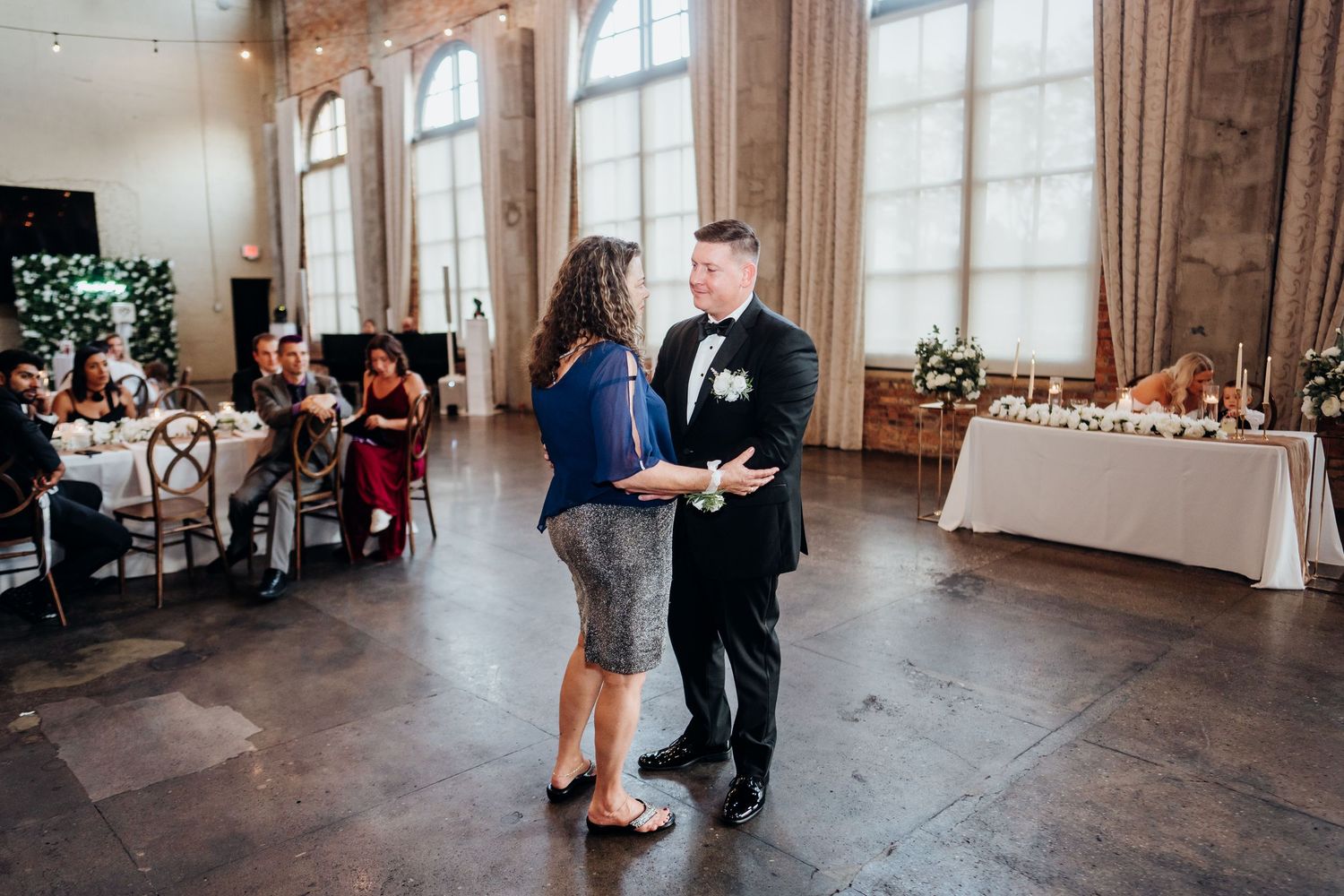 Wedding reception venue decorated with string lights and elegant drapery.