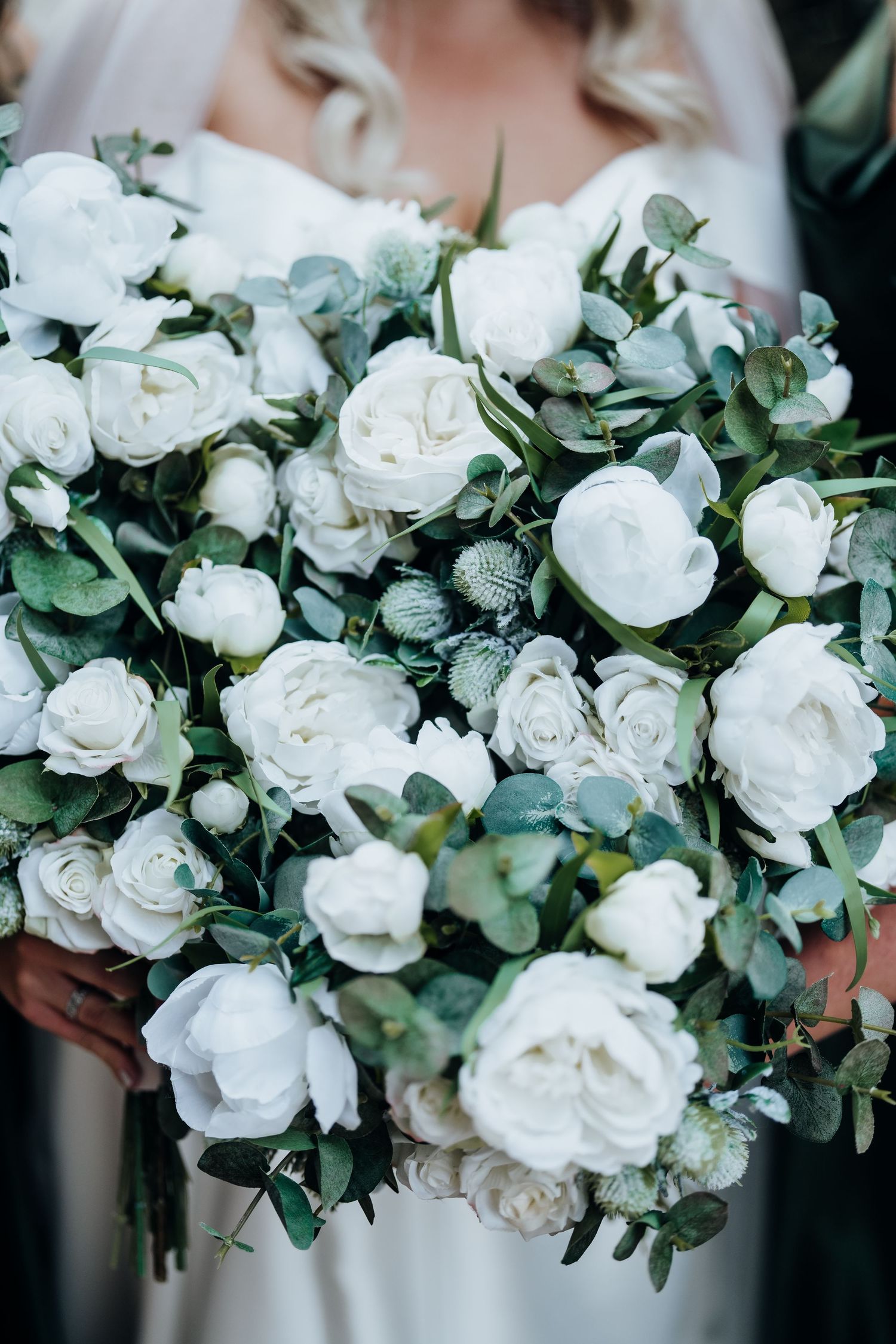 Close-up shots of elegant white rose and eucalyptus wedding bouquets.