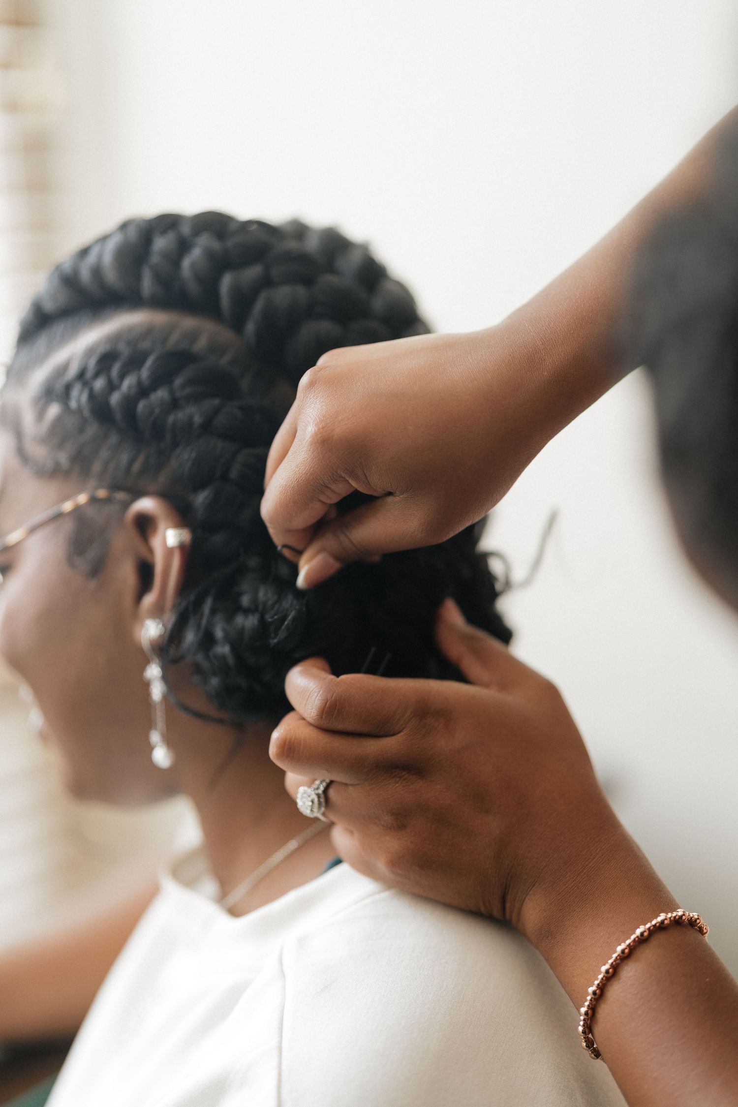 Close-up sequence of hands styling and pinning dark hair for a formal occasion.