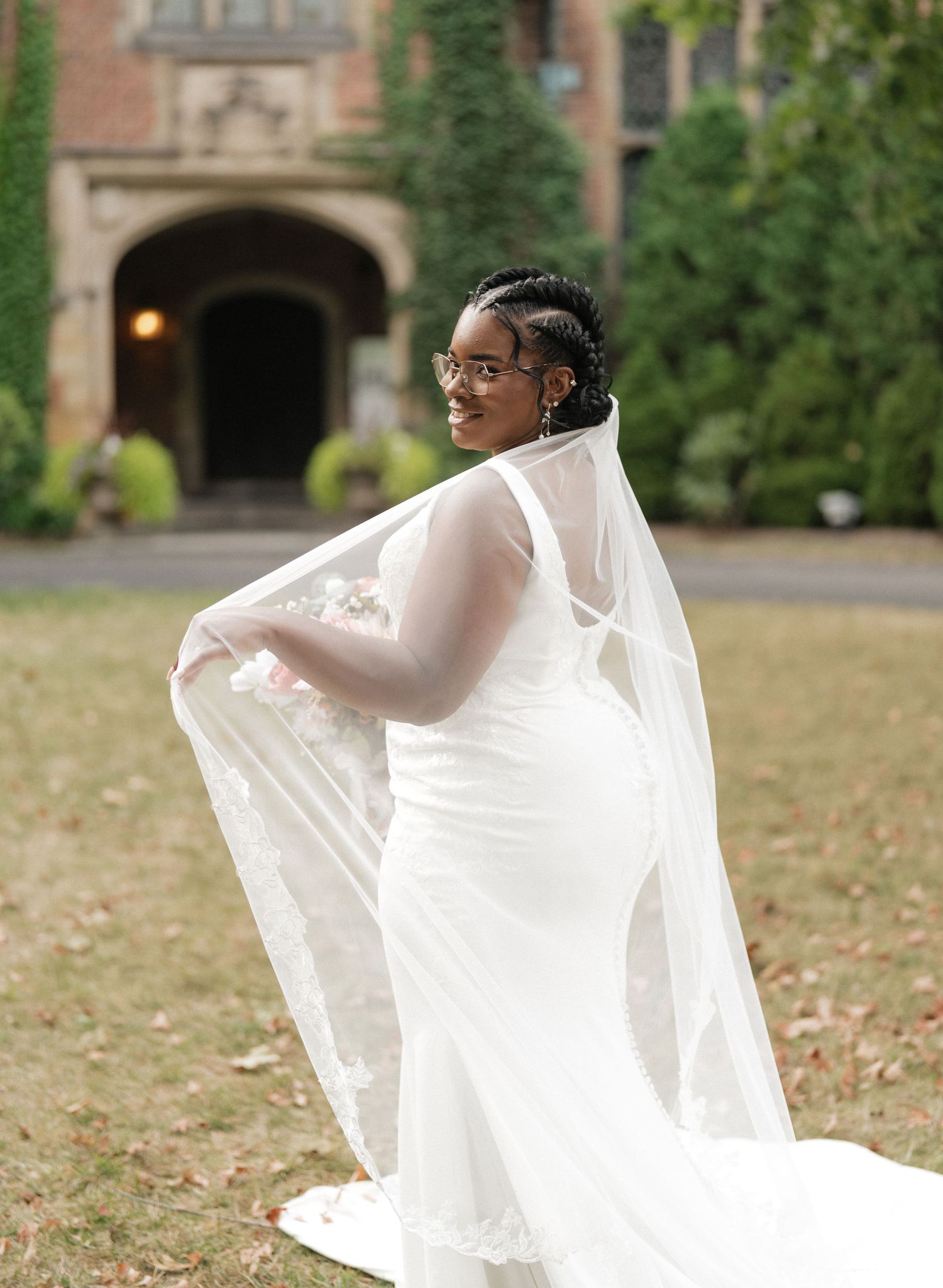 Bride twirling in flowing white dress on autumn lawn.