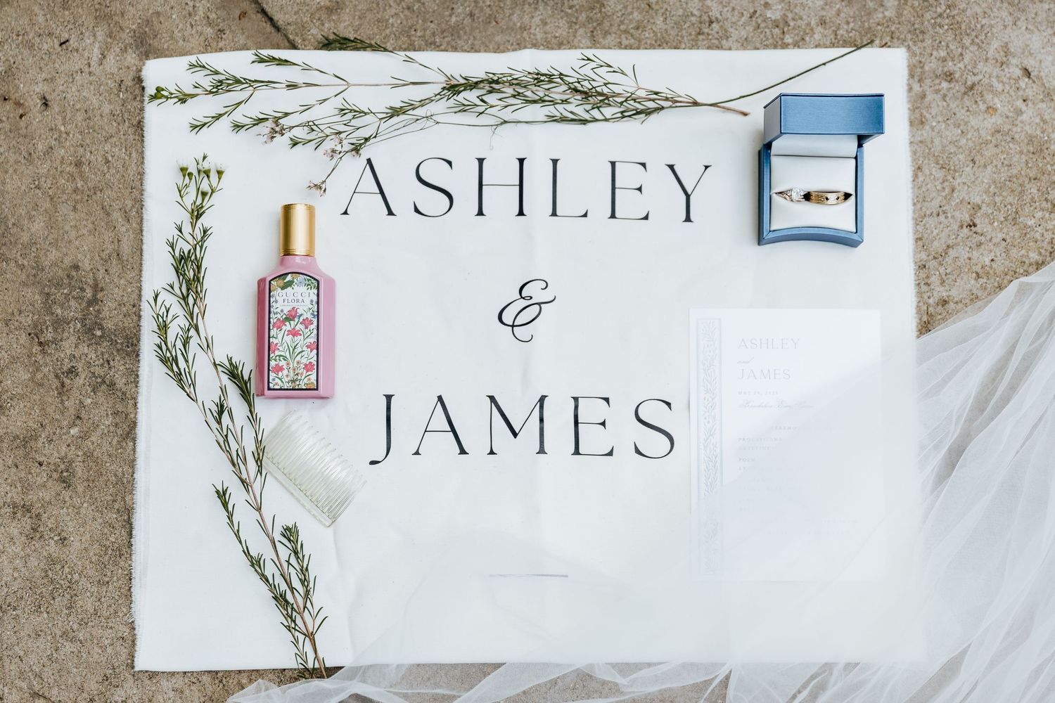 Elegant wedding invitation design with delicate floral wreath and calligraphy text on textured paper background.