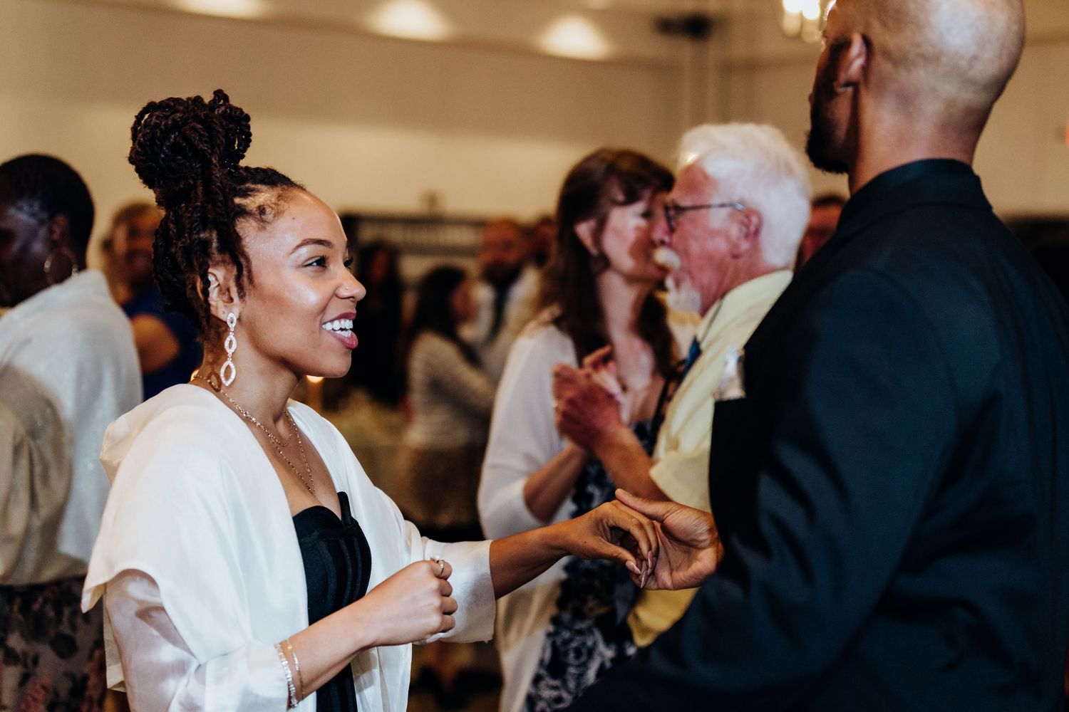 Wedding reception guests enjoying festivities in an indoor venue.