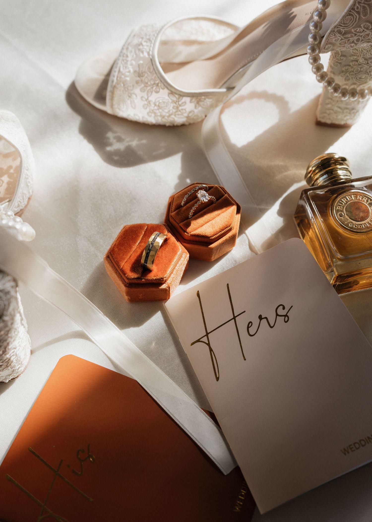 Wedding details including perfume bottles and elegant place cards in soft lighting.