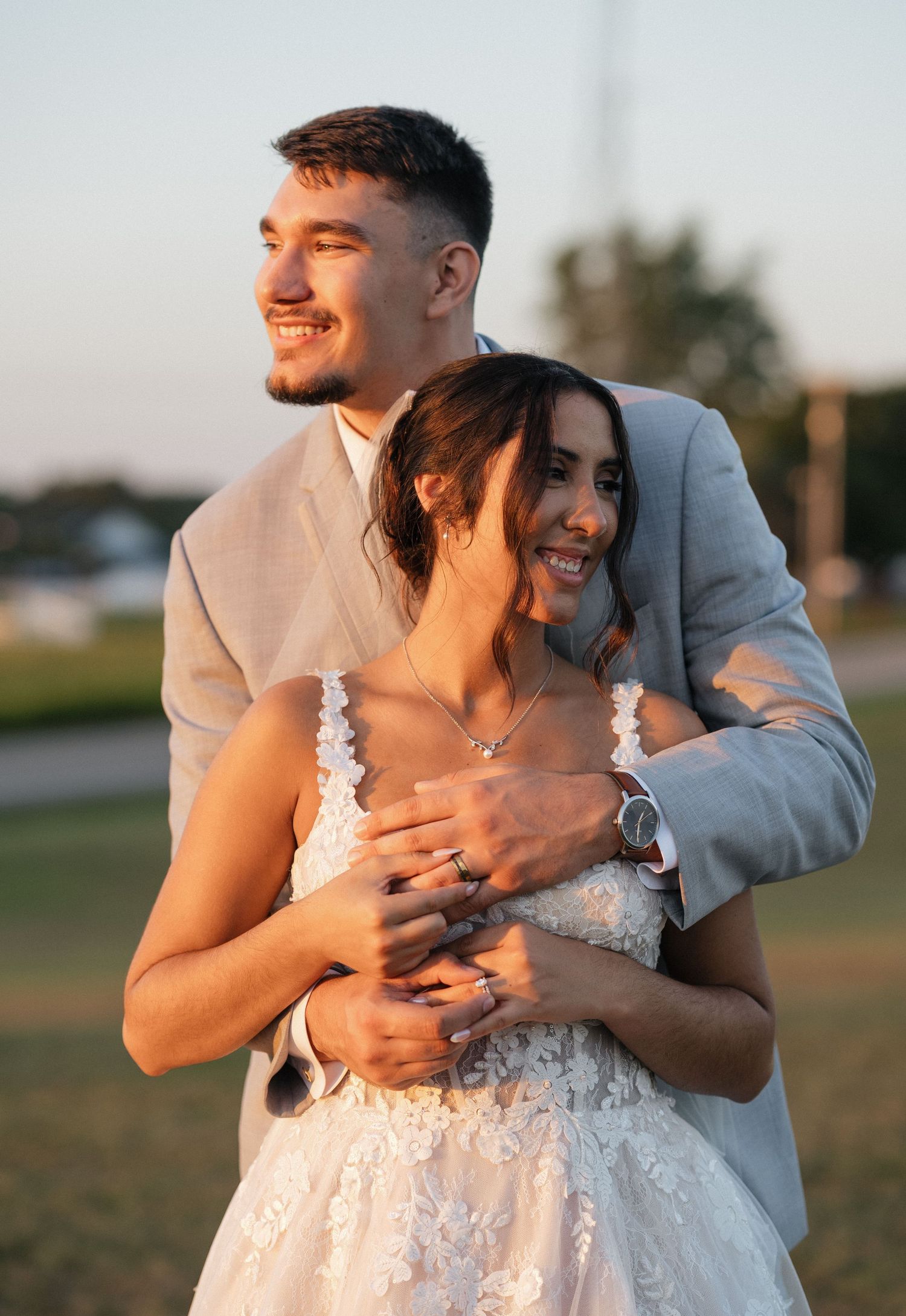 Newlyweds share tender moments during their sunset wedding photoshoot in an outdoor setting.