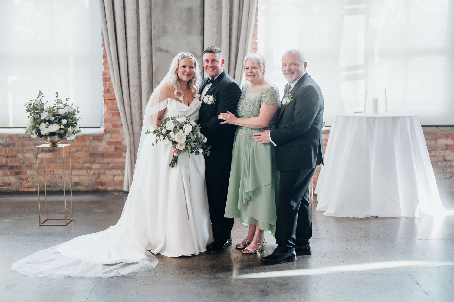 A wedding celebration in an industrial venue with exposed brick and large windows.