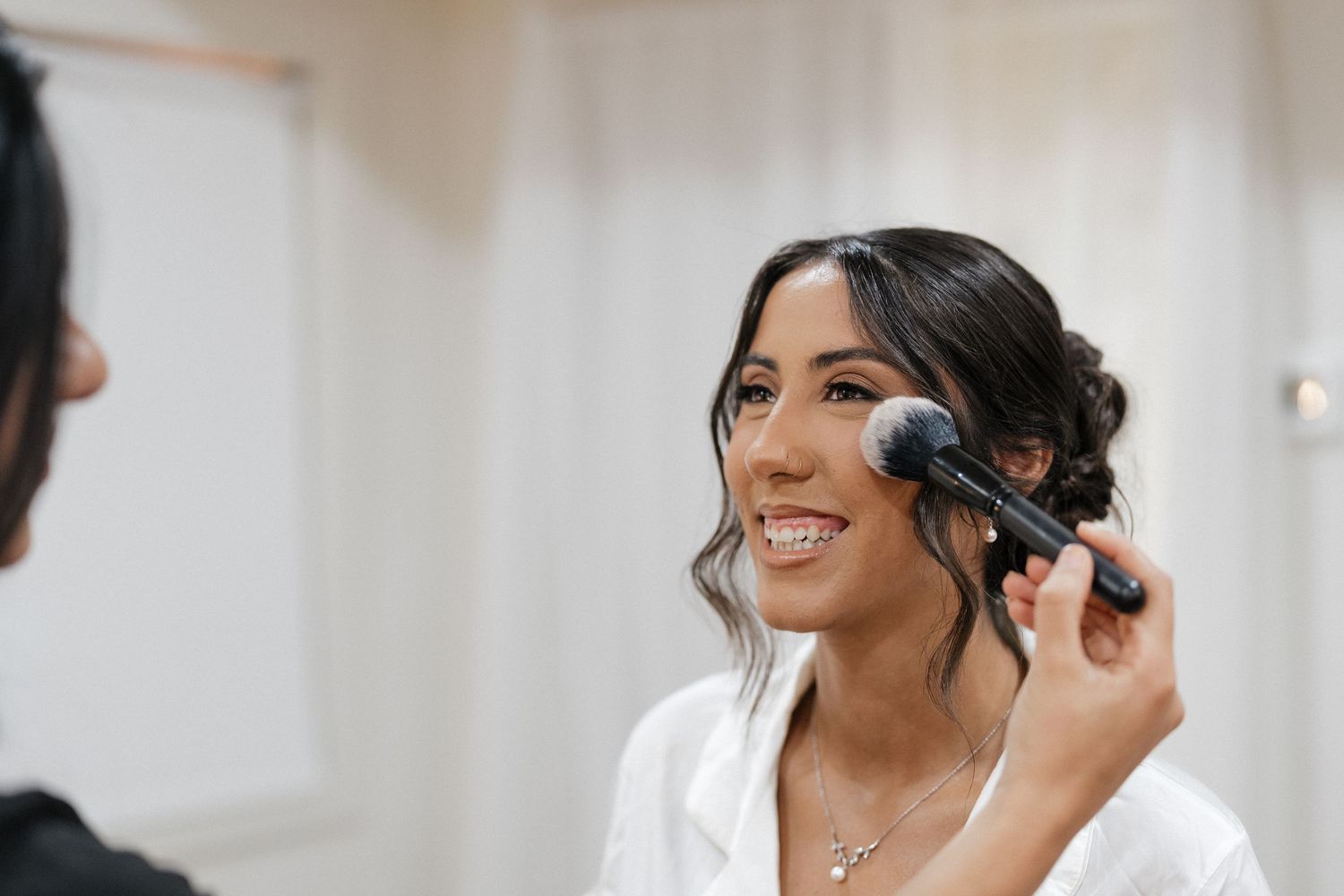 Getting ready scene with makeup brushes and styling tools in a bright room with natural light.
