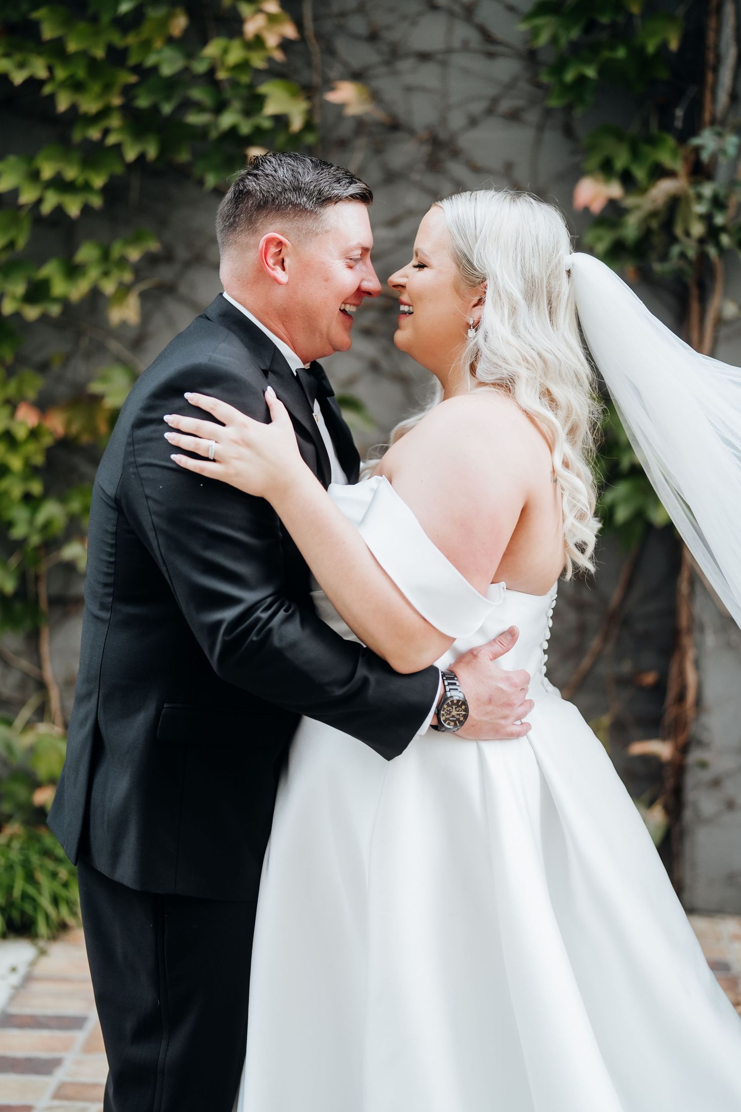 Romantic outdoor wedding portraits against an ivy-covered wall.