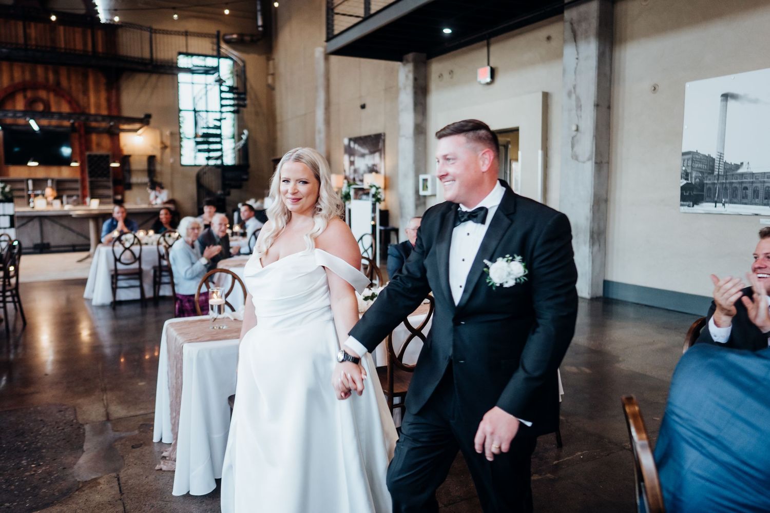 Candid wedding moments captured in an industrial-style reception space.