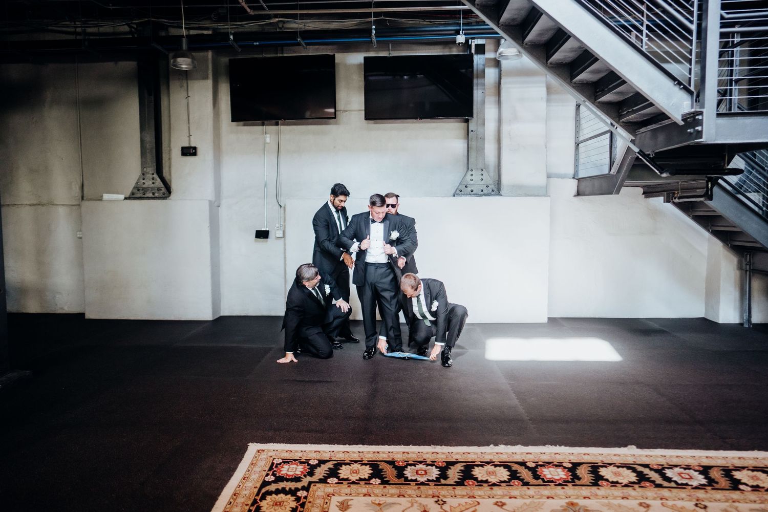 An industrial style venue space with exposed brick walls and dark flooring.