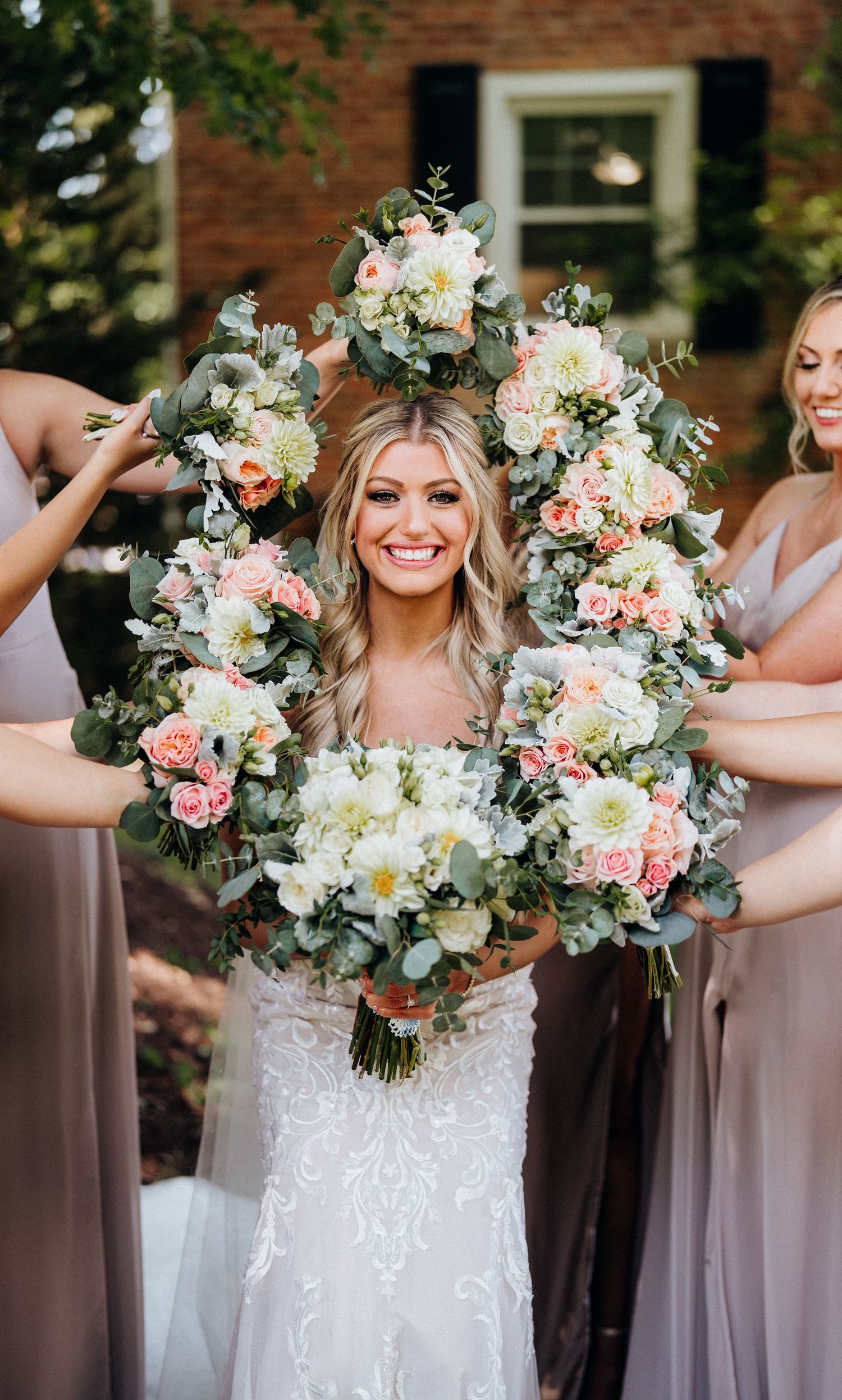 Beautiful wedding bouquets arranged in a circle with soft pink and white flowers.