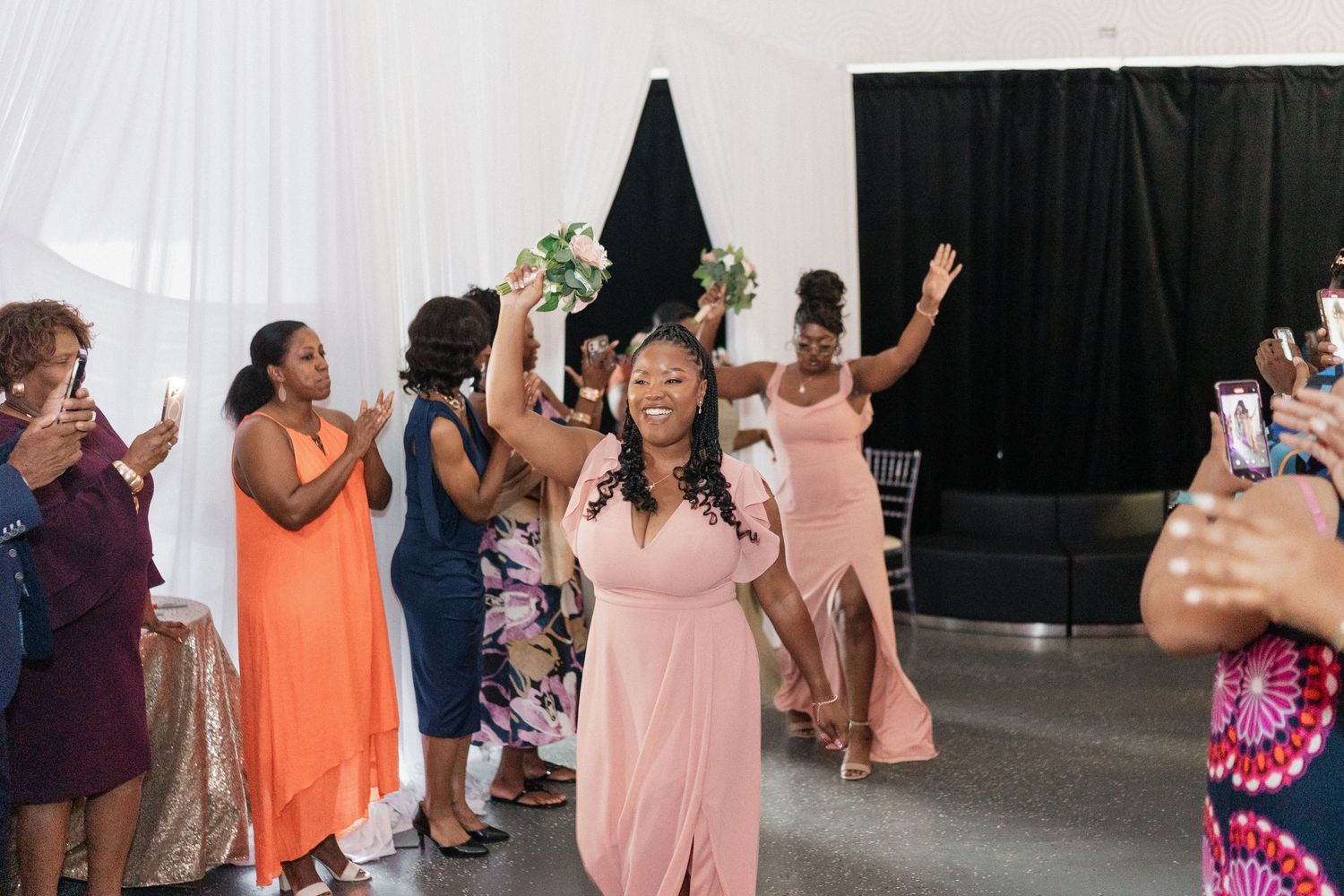Wedding guests celebrating on the dance floor with enthusiastic moves and bright attire.