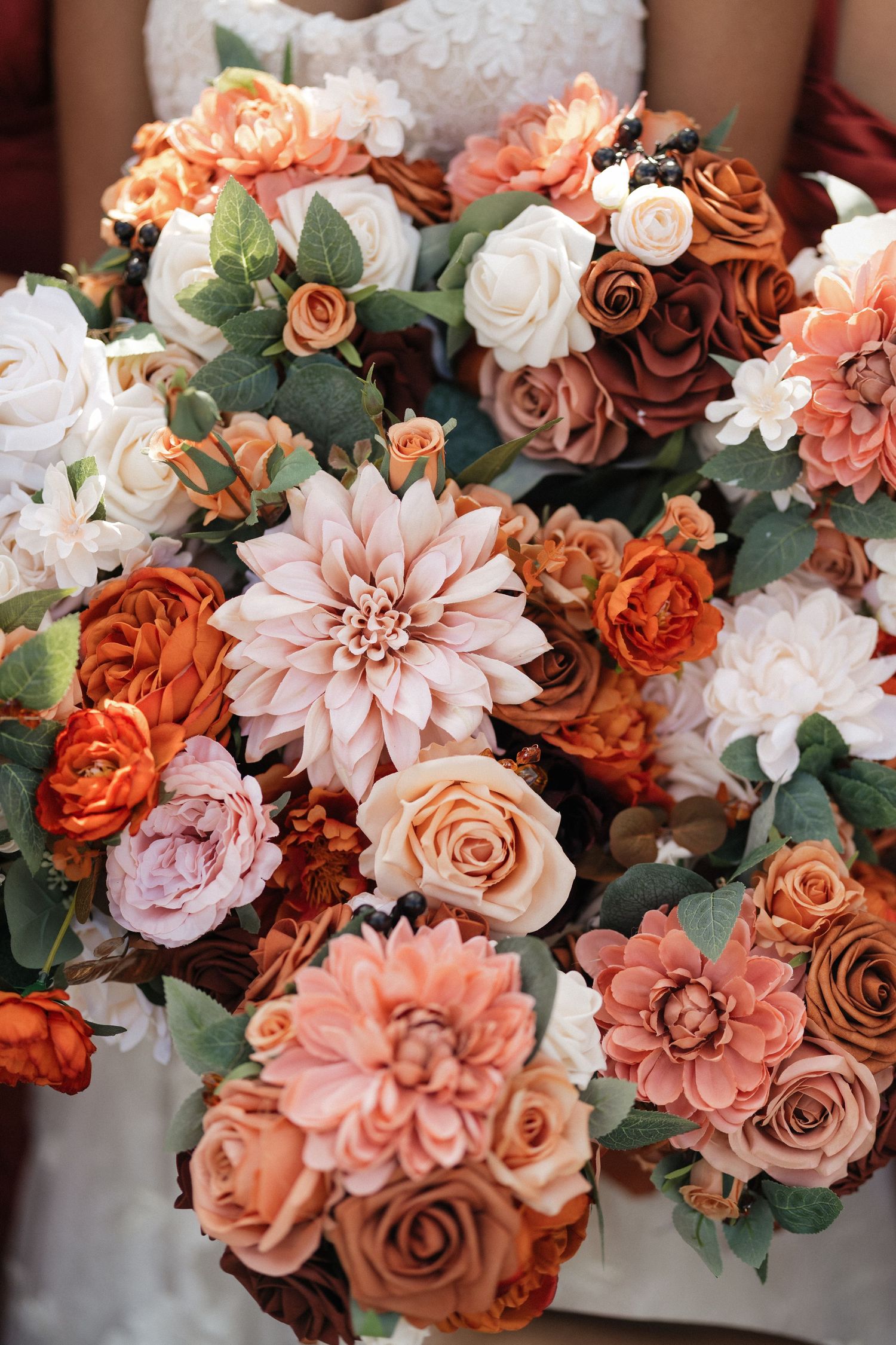 Stunning floral arrangement featuring coral, peach and white roses with greenery.