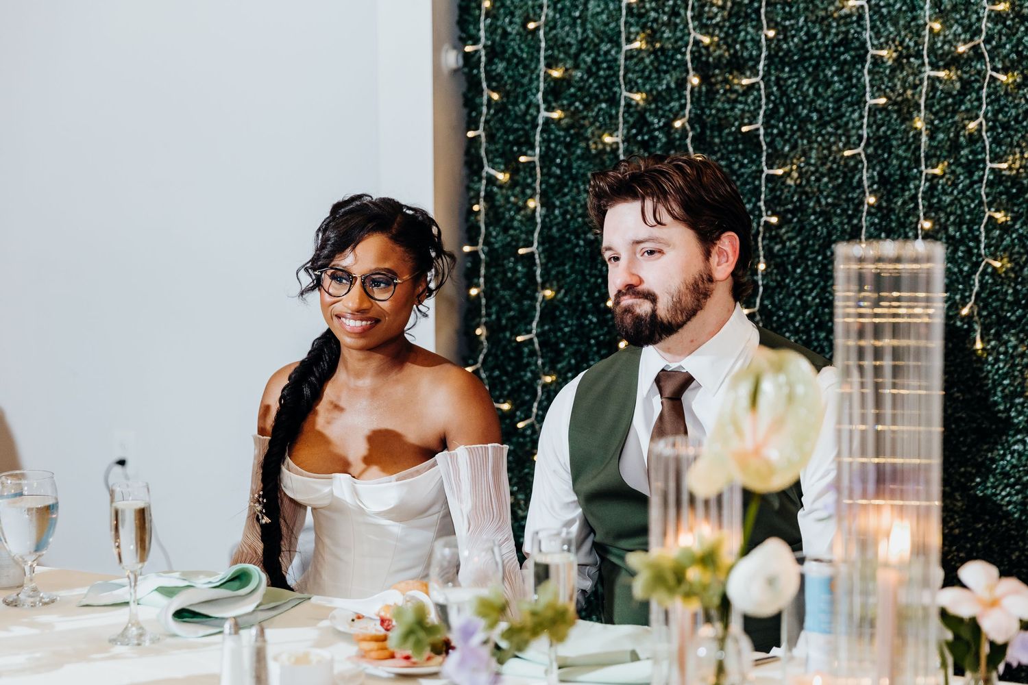 Reception dinner setup with elegant lighting and table settings for wedding celebration.