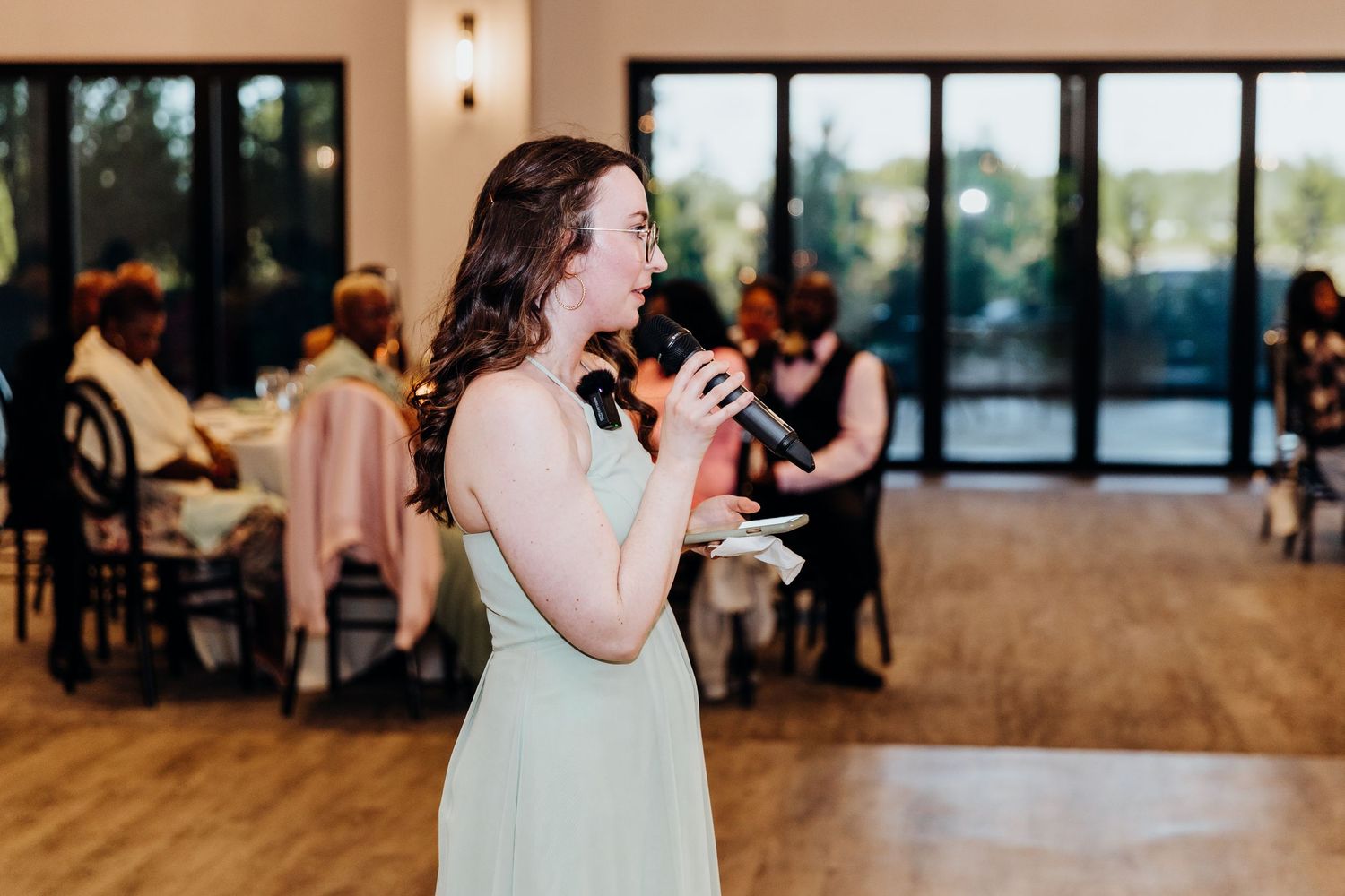 Wedding reception venue with warm lighting and guests celebrating at tables.