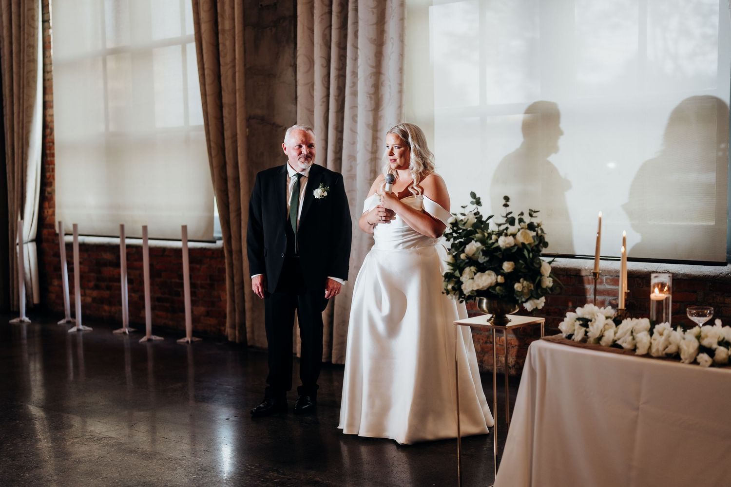 Elegant wedding ceremony setup in venue with natural lighting and draped fabric decor.