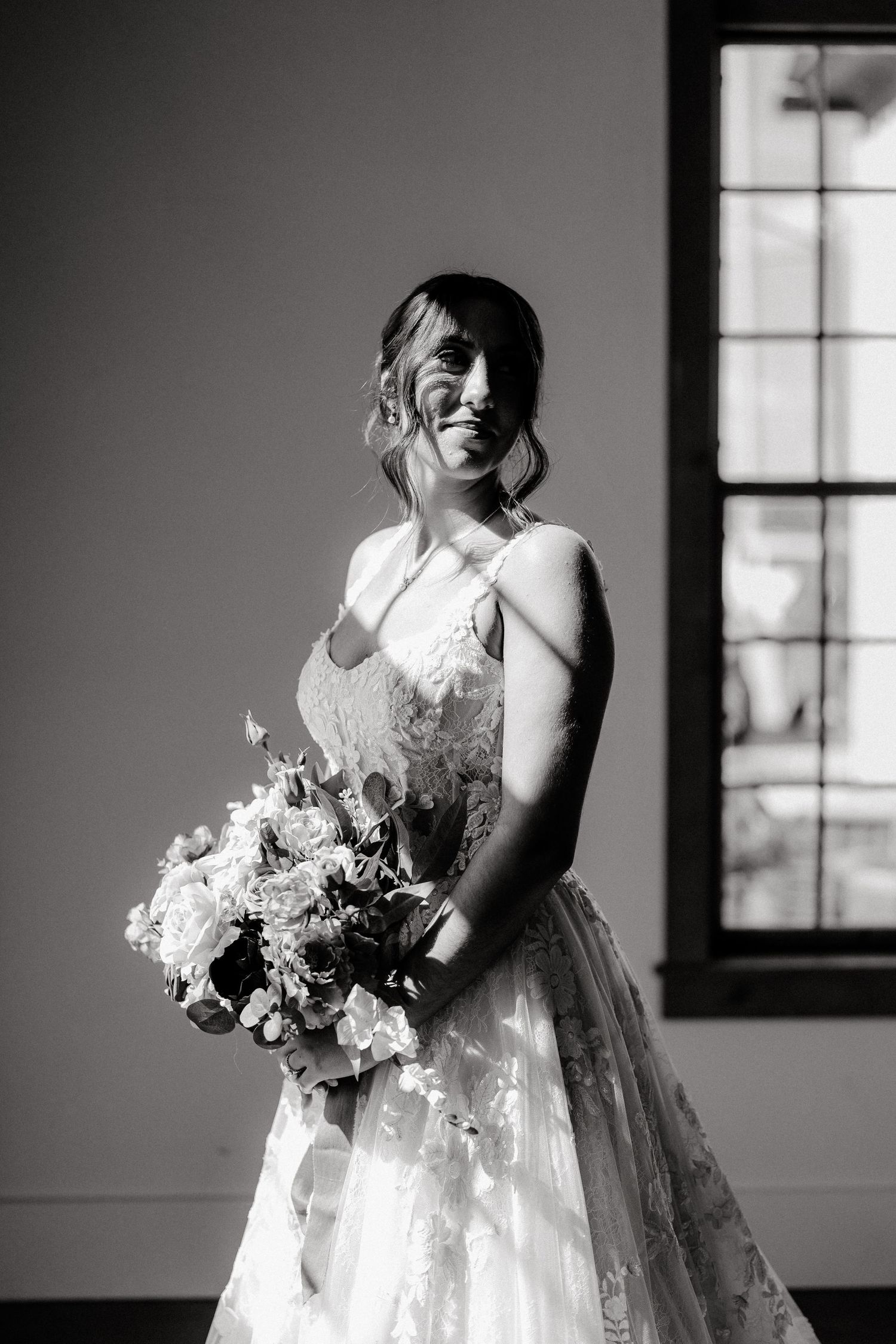 Black and white photos of a bride holding a bouquet in a sunlit room.